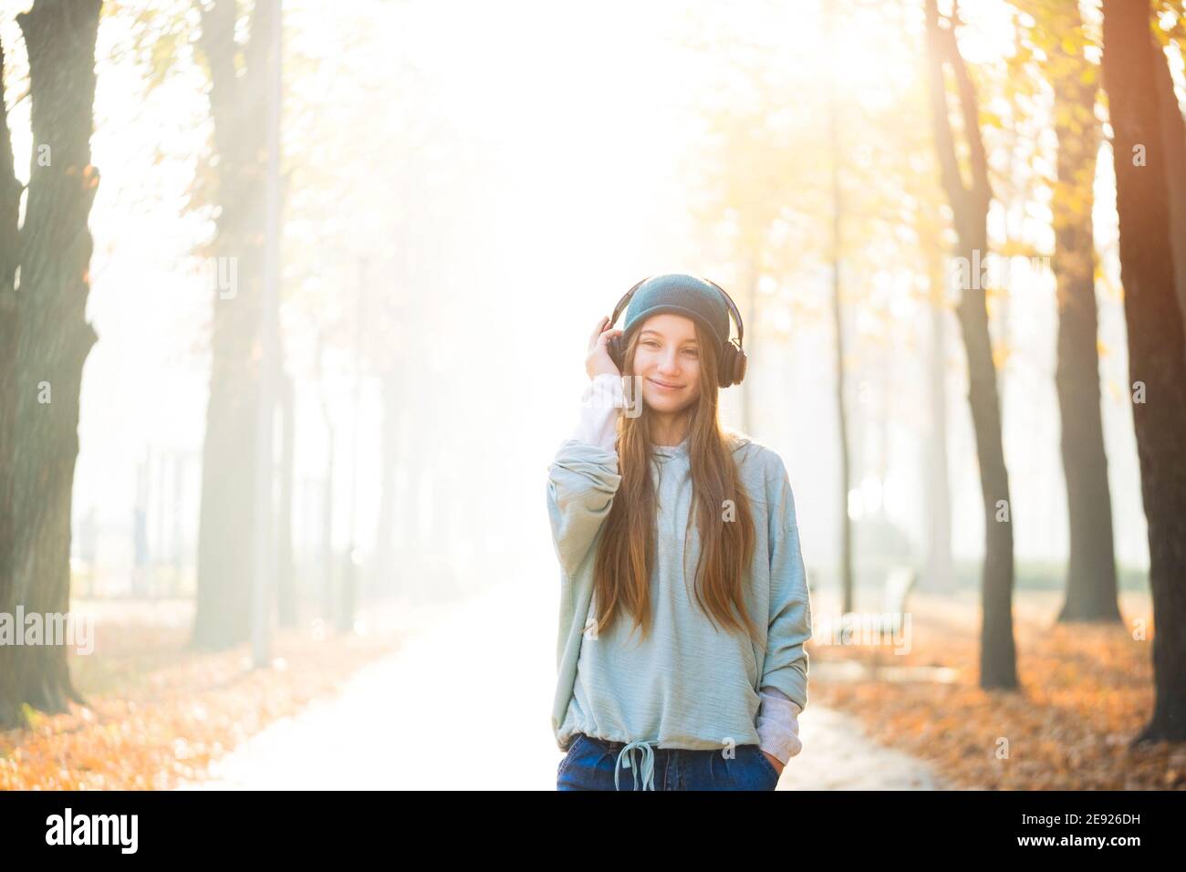 Belle fille écoutant de la musique dans les écouteurs dans le parc Banque D'Images