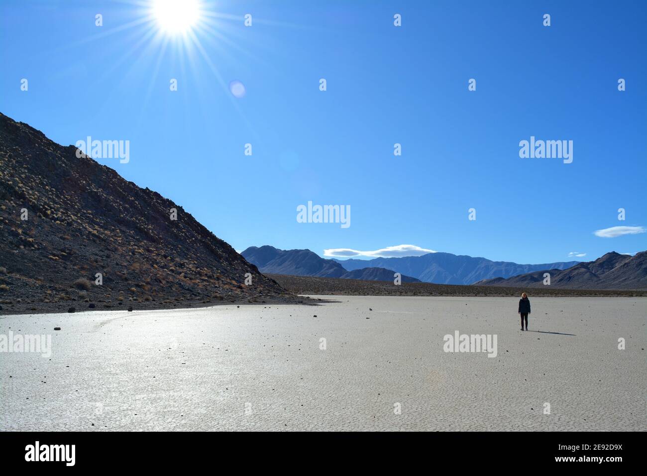 Femme marchant sur l'hippodrome Playa lors d'une journée froide de décembre dans le parc national de la Vallée de la mort, magnifique paysage avec les rochers en mouvement laissant des pistes Banque D'Images