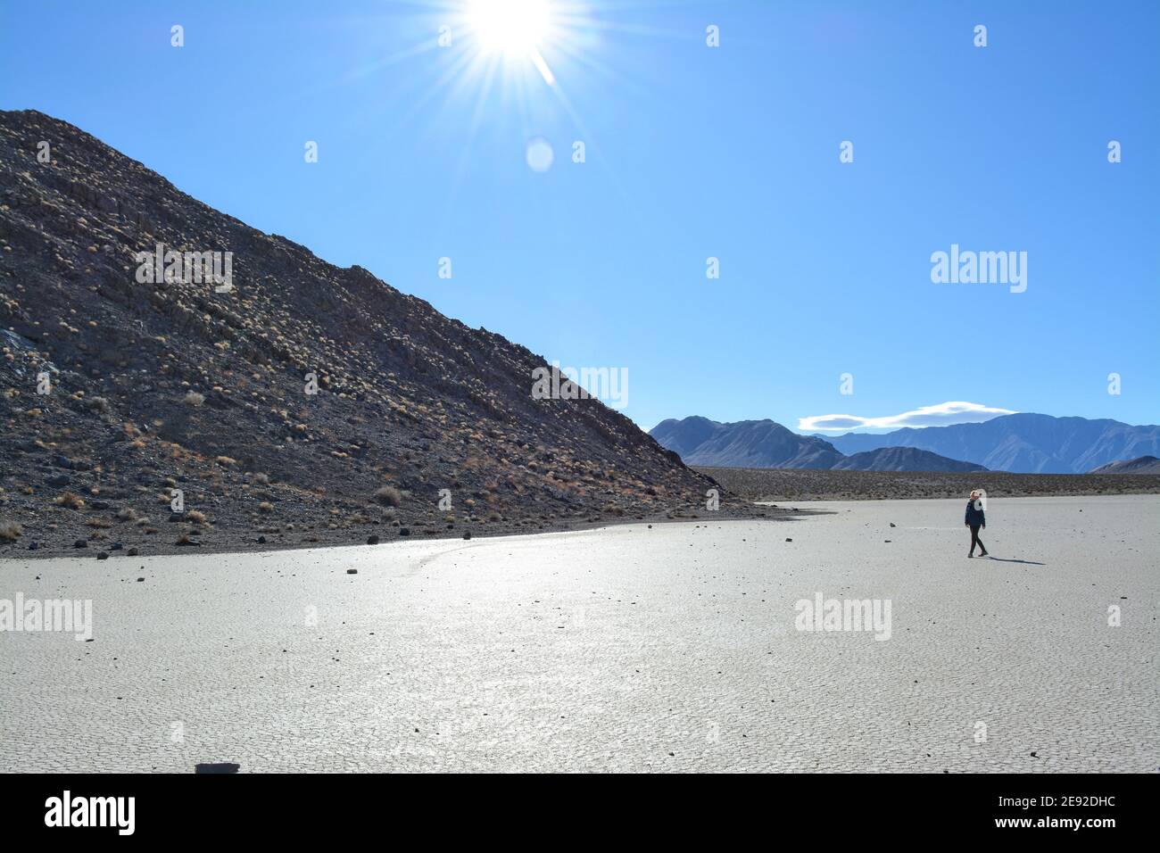 Femme marchant sur l'hippodrome Playa lors d'une journée froide de décembre dans le parc national de la Vallée de la mort, magnifique paysage avec les rochers en mouvement laissant des pistes Banque D'Images