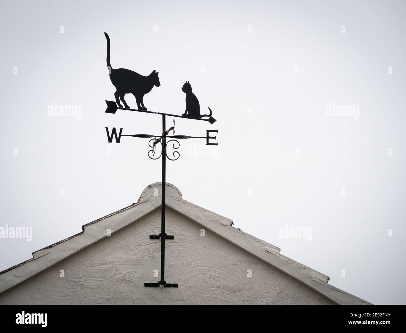 Girouette décorée de deux chats. L'une assise et l'autre debout avec la queue dans l'air. Banque D'Images