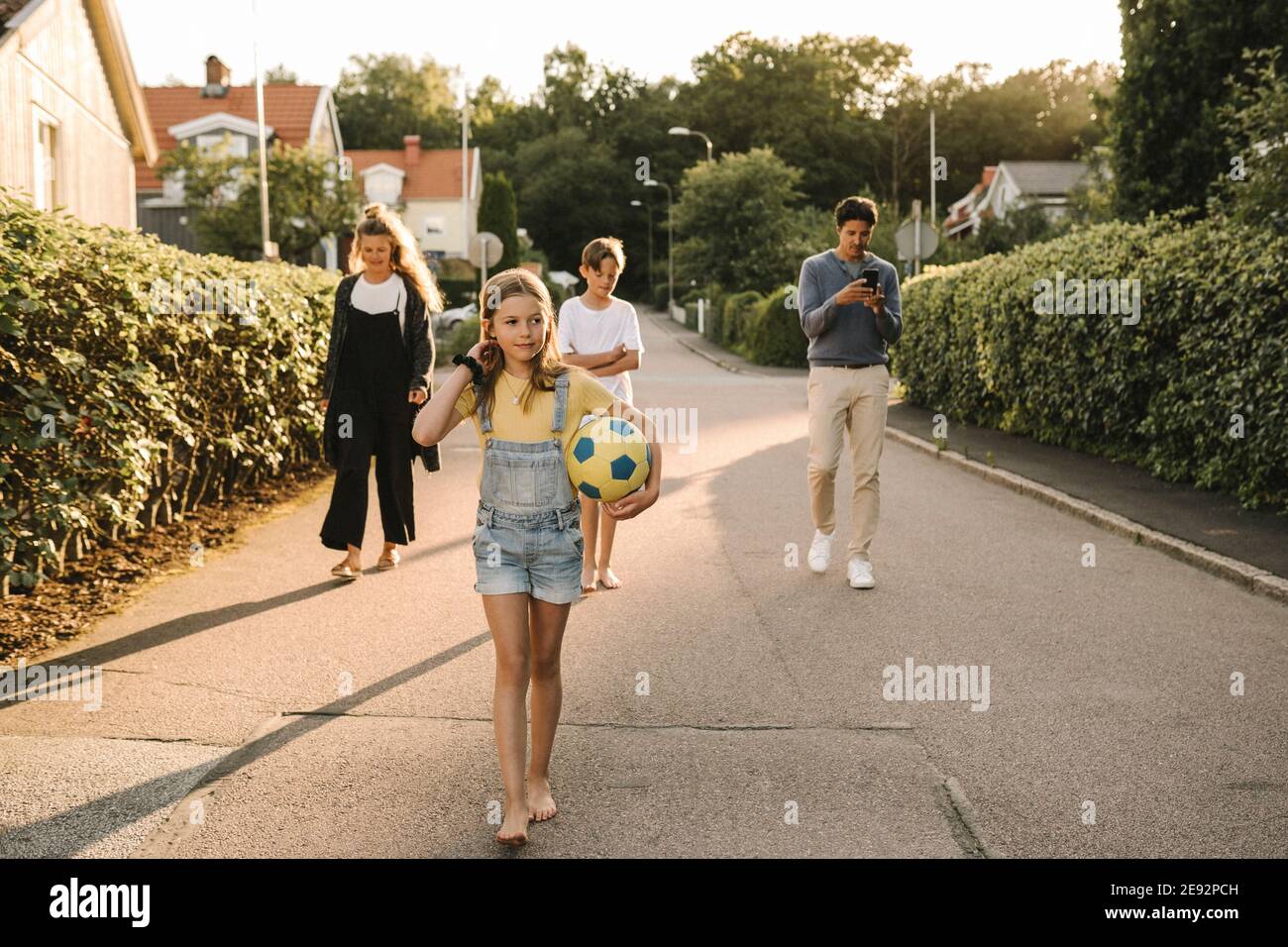 Enfants marchant avec leurs parents sur la route Banque D'Images