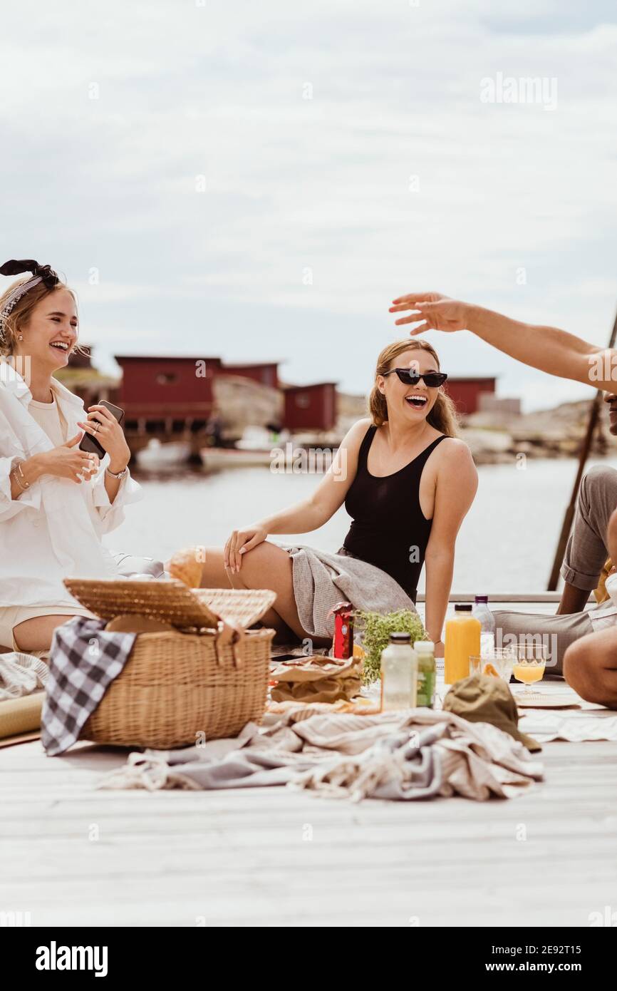 Des amis gais passent du temps libre par la mer au port Banque D'Images