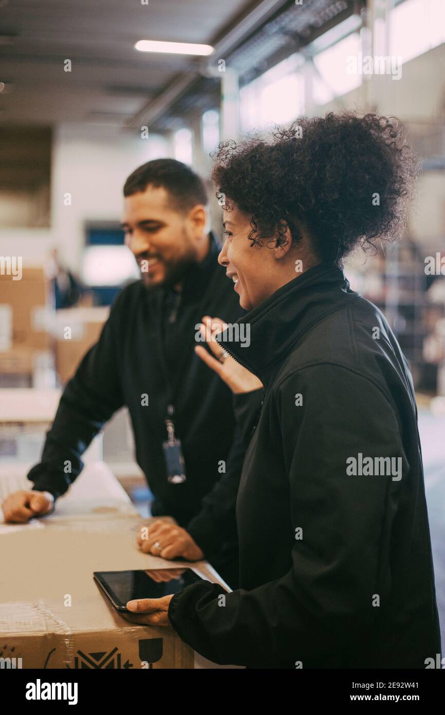 Souriant hommes et femmes travailleurs manuels à l'entrepôt Banque D'Images