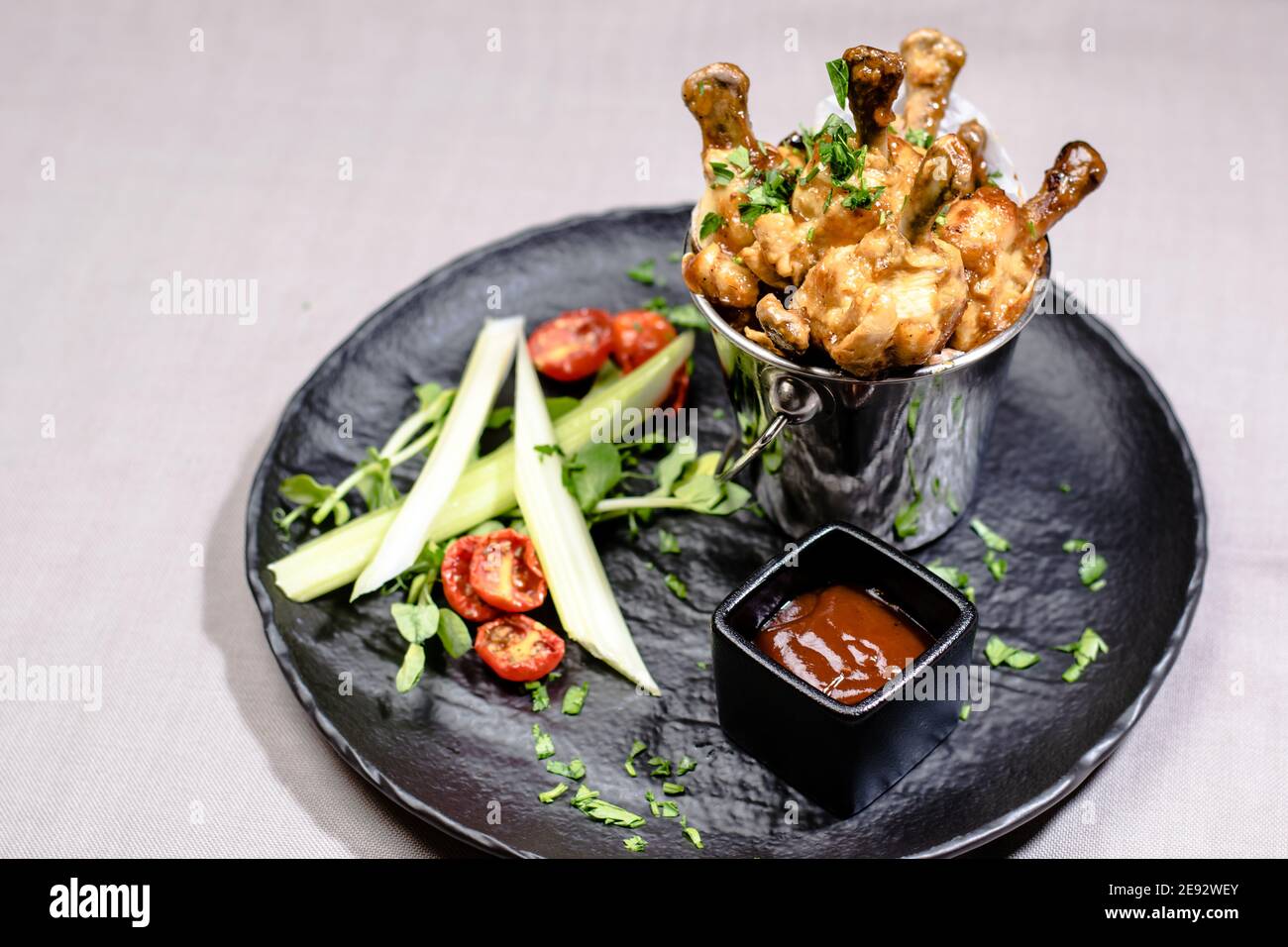 Checken frit dans un seau décoratif avec des légumes à un restaurant Banque D'Images