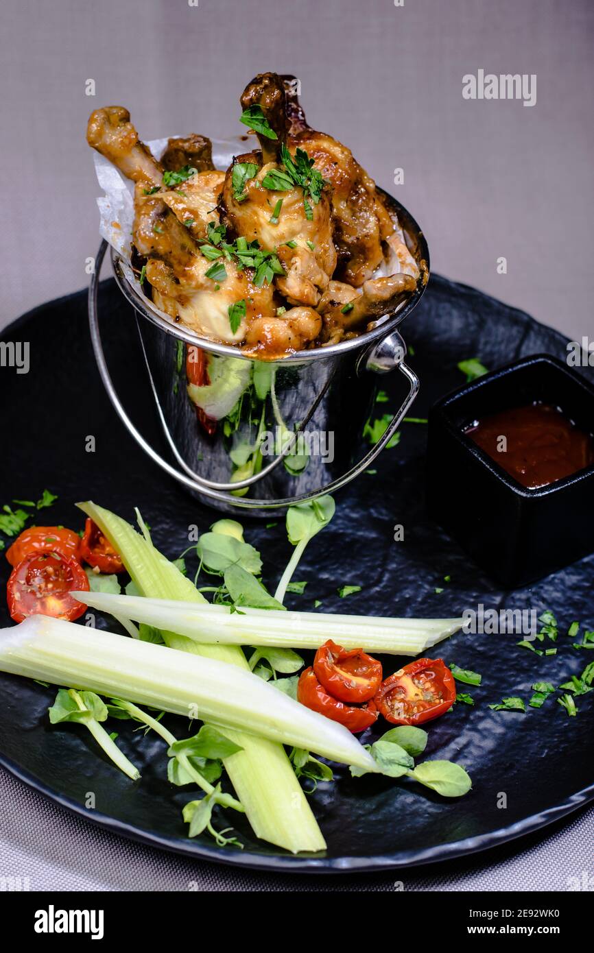 Checken frit dans un seau décoratif avec des légumes à un restaurant Banque D'Images