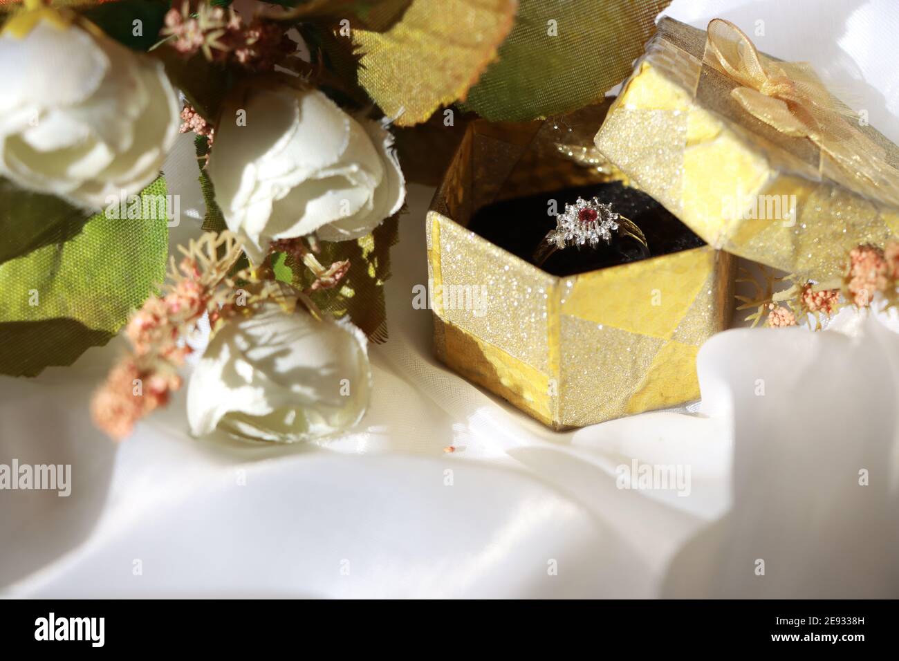 Engagement et mariage bague diamant argent avec un rubis dans Boîte cadeau avec fond blanc et bouquet de mariée Banque D'Images
