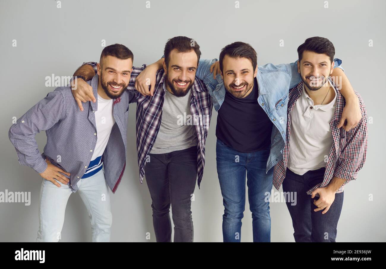 Portrait de groupe de jeunes amis heureux qui s'embrasent, sourient et s'amusent en studio Banque D'Images