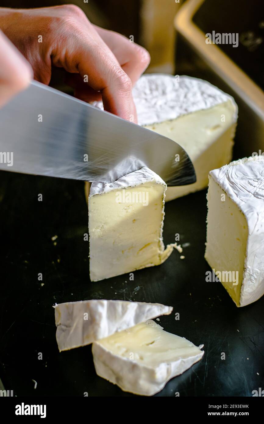 Chef cuisinier qui coupe du fromage dans un restaurant Banque D'Images