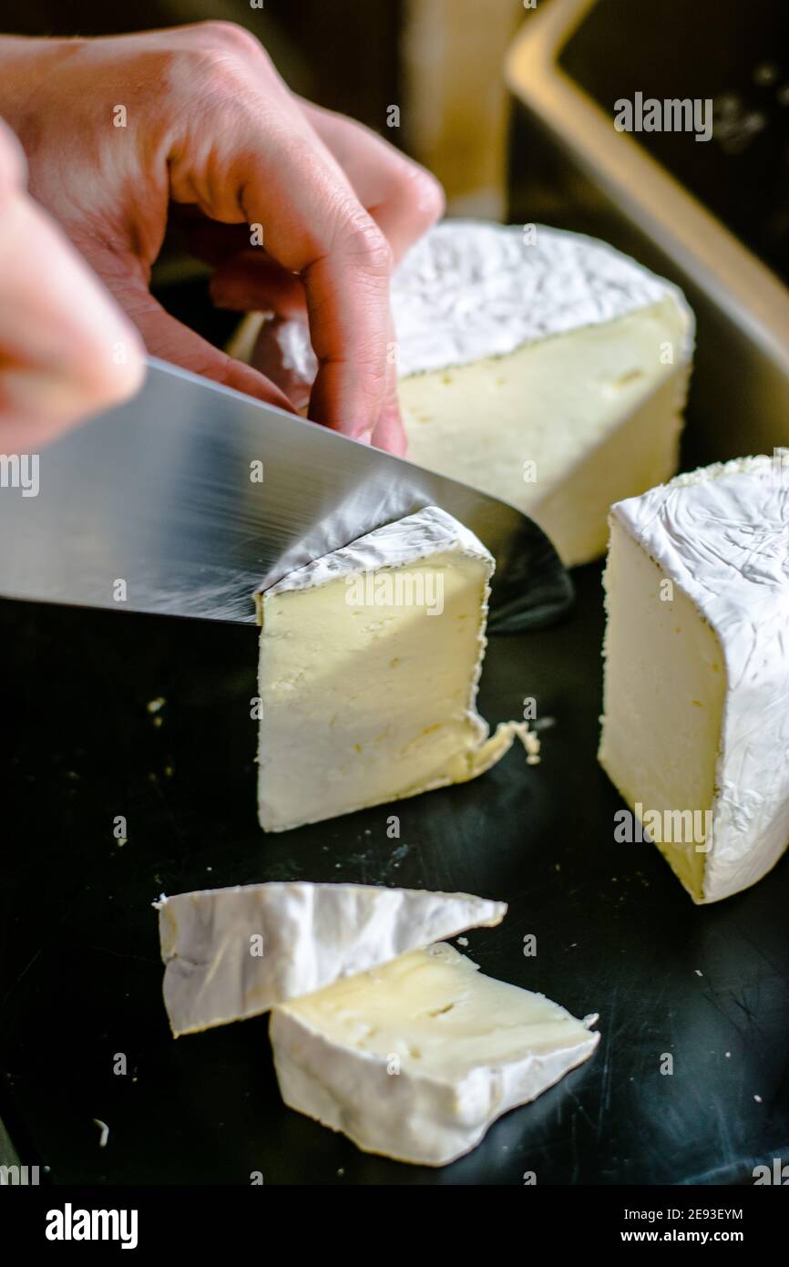 Chef cuisinier qui coupe du fromage dans un restaurant Banque D'Images