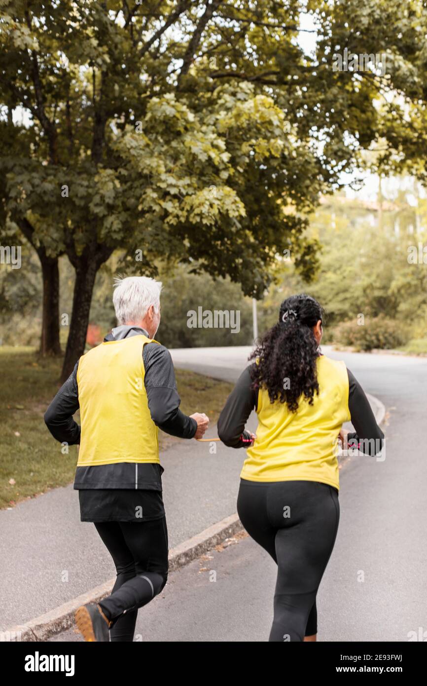 Femme malvoyante qui fait du jogging avec guide Banque D'Images