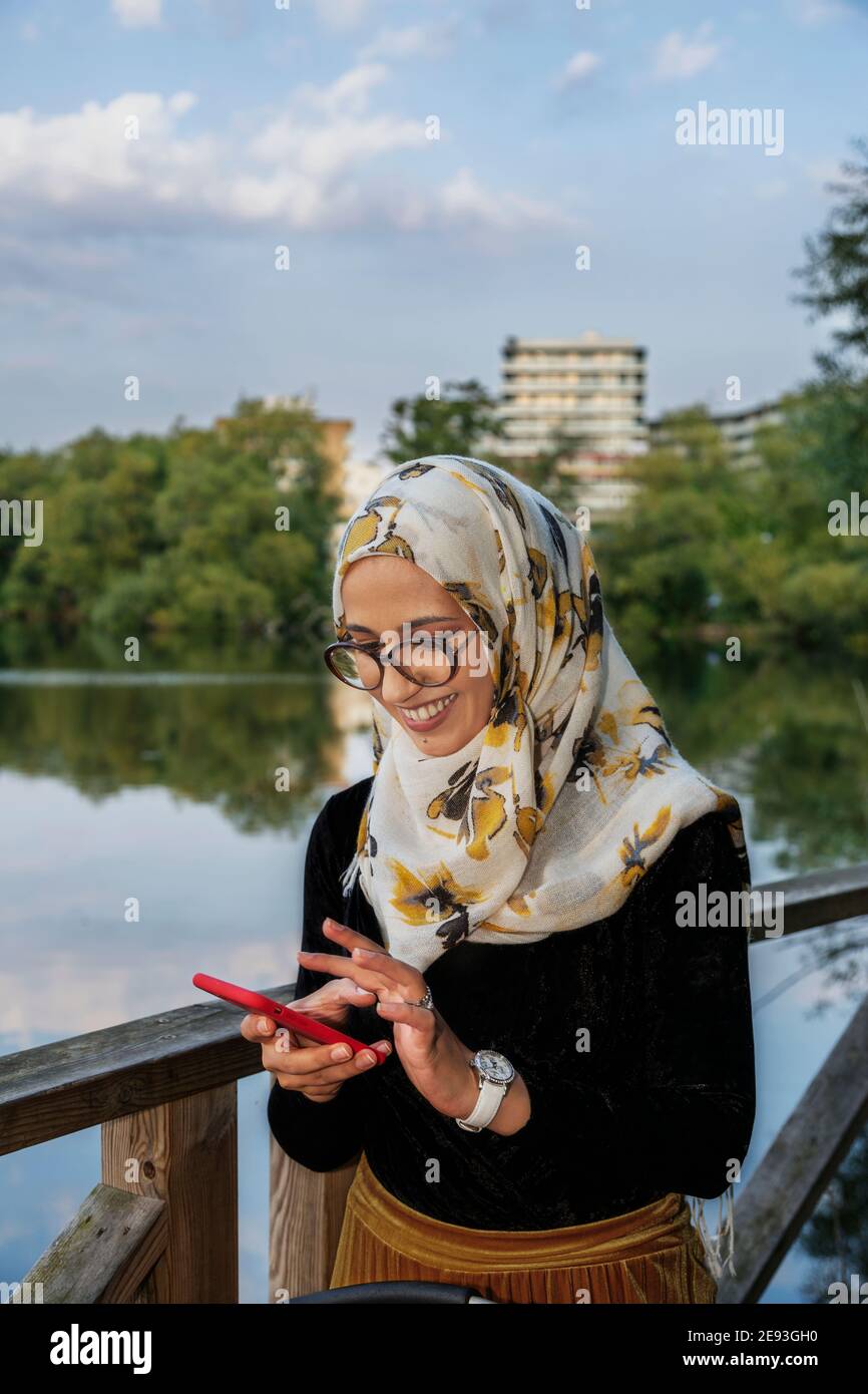 Smiling young woman using cell phone Banque D'Images