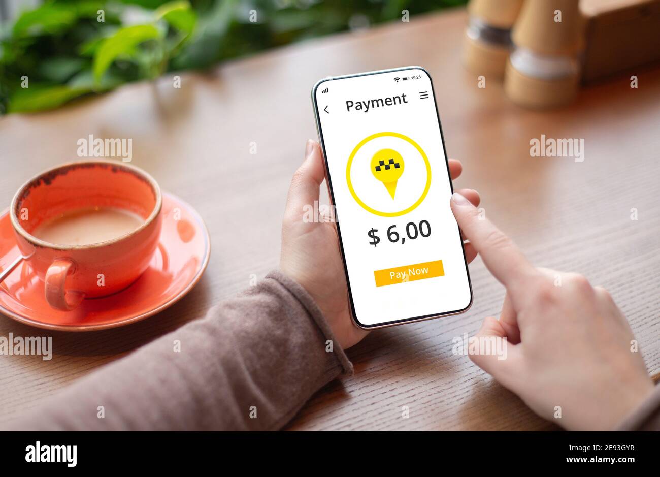 Femme méconnaissable réservant un taxi en ligne, en utilisant une application de téléphone mobile, en payant le trajet sur le Web au café Banque D'Images