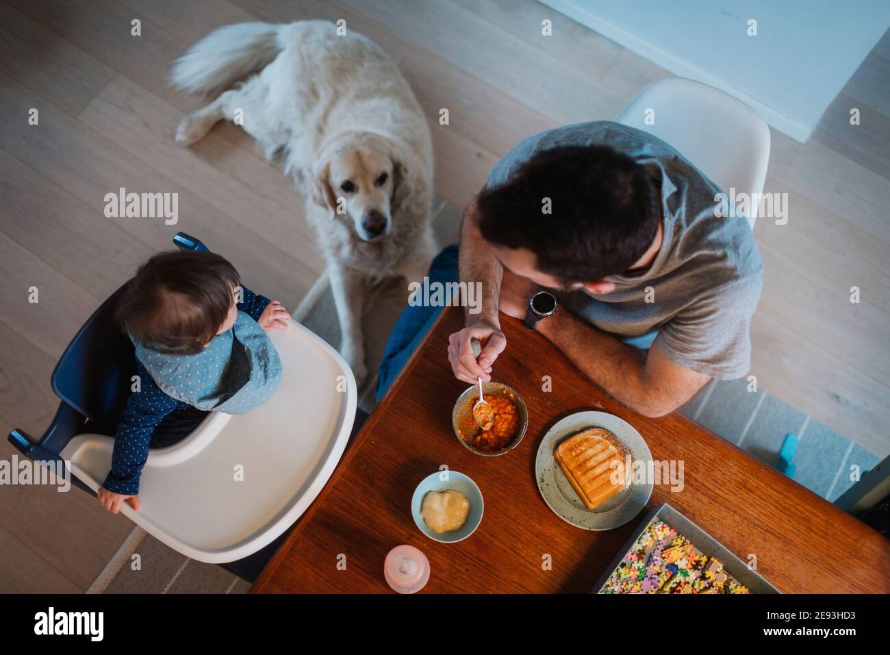 Père nourrissant le tout-petit à la table Banque D'Images