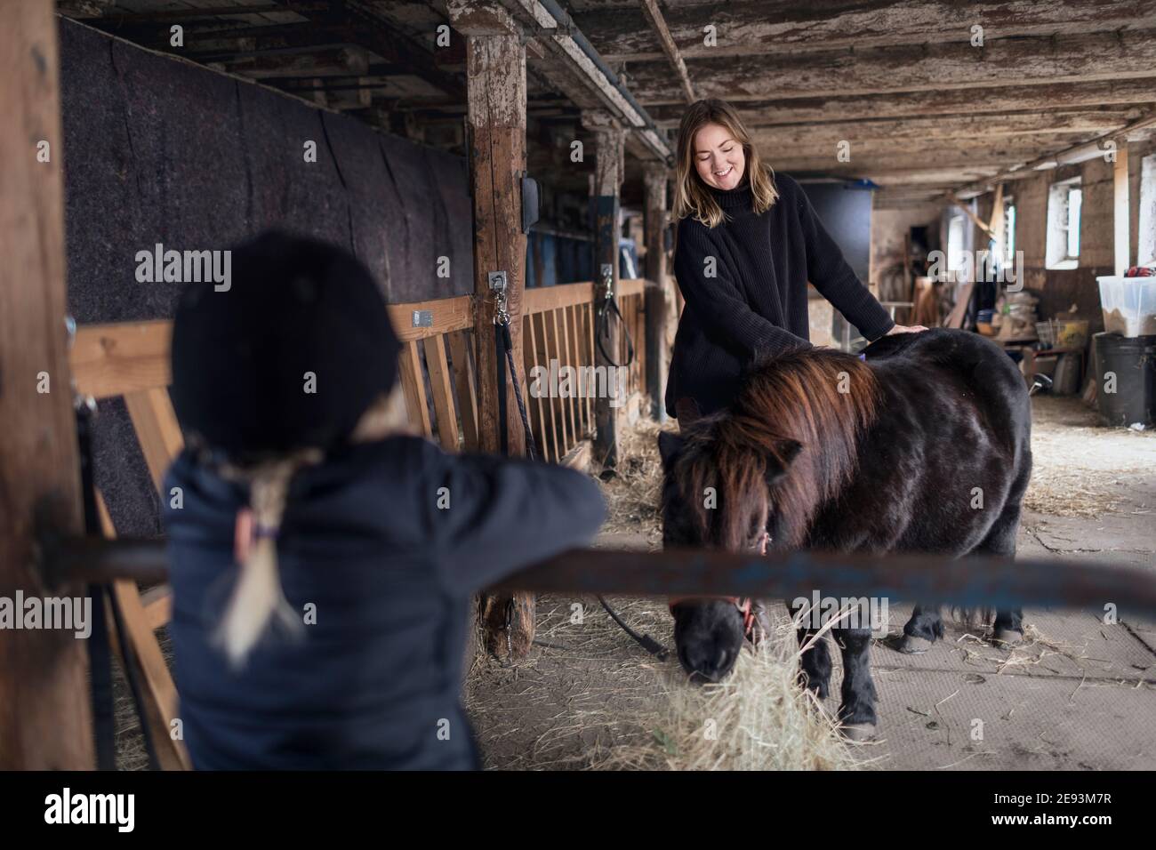 Mère et fille avec cheval dans l'écurie Banque D'Images