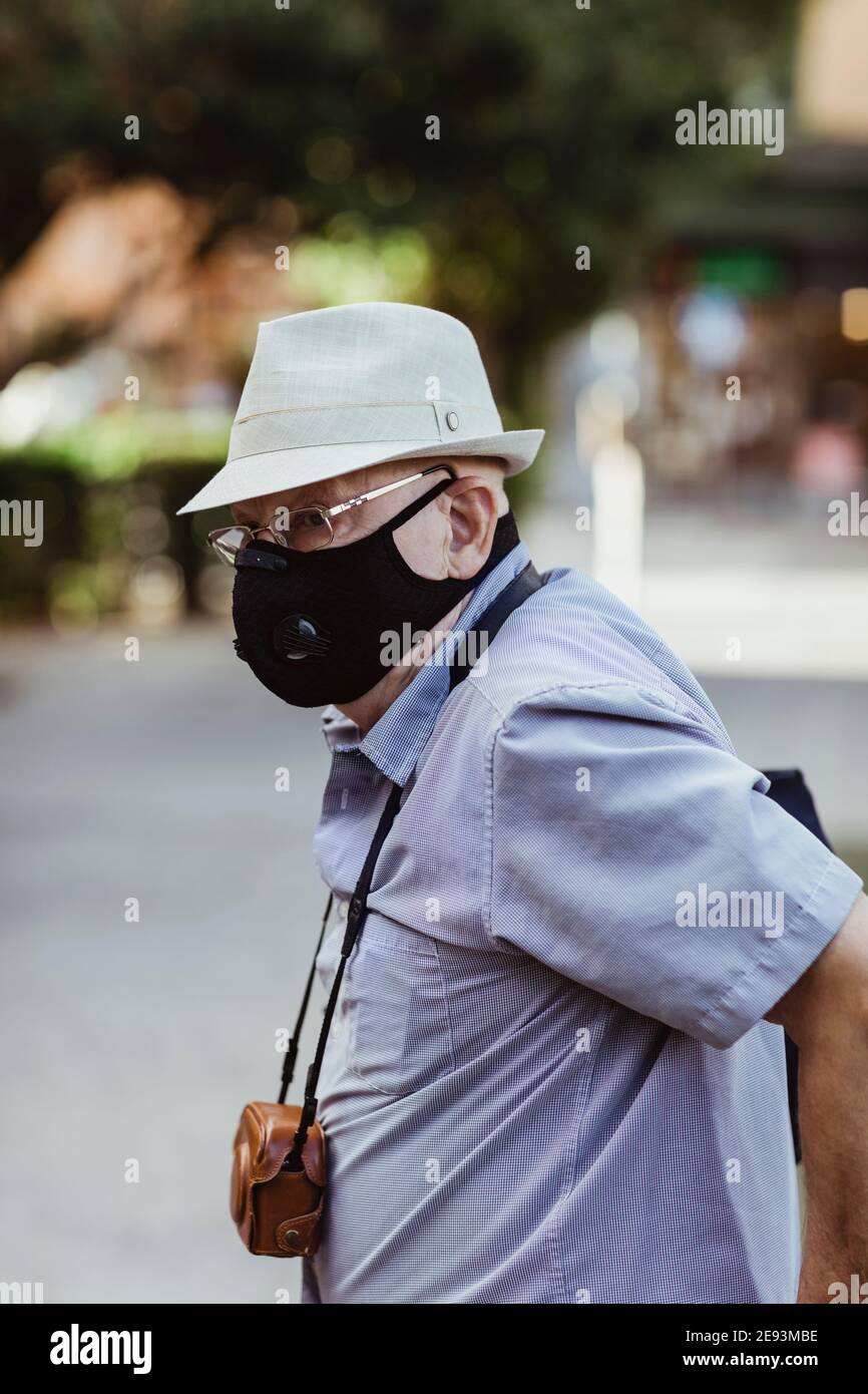 Homme âgé avec masque facial de protection debout dans le parc Banque D'Images