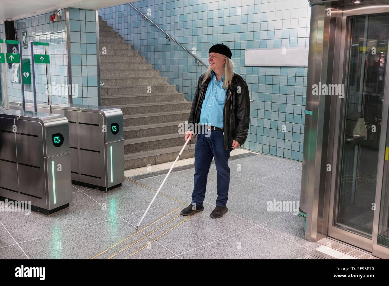 Homme avec canne blanche debout à la station de métro Banque D'Images