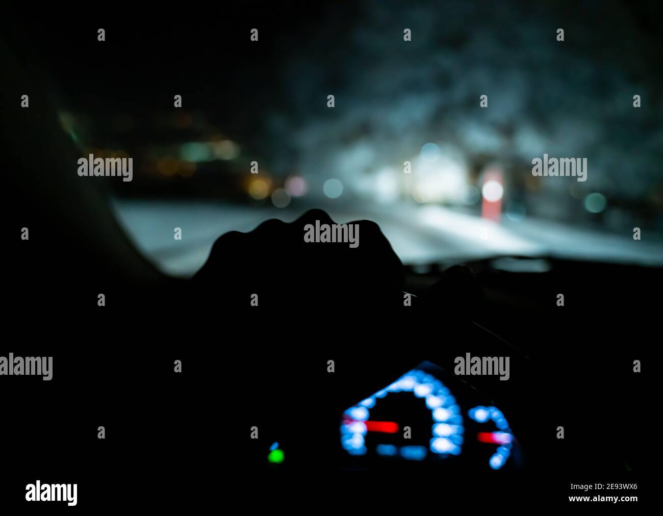 Silhouette d'une main tenant le volant d'une voiture pendant la conduite. Banque D'Images