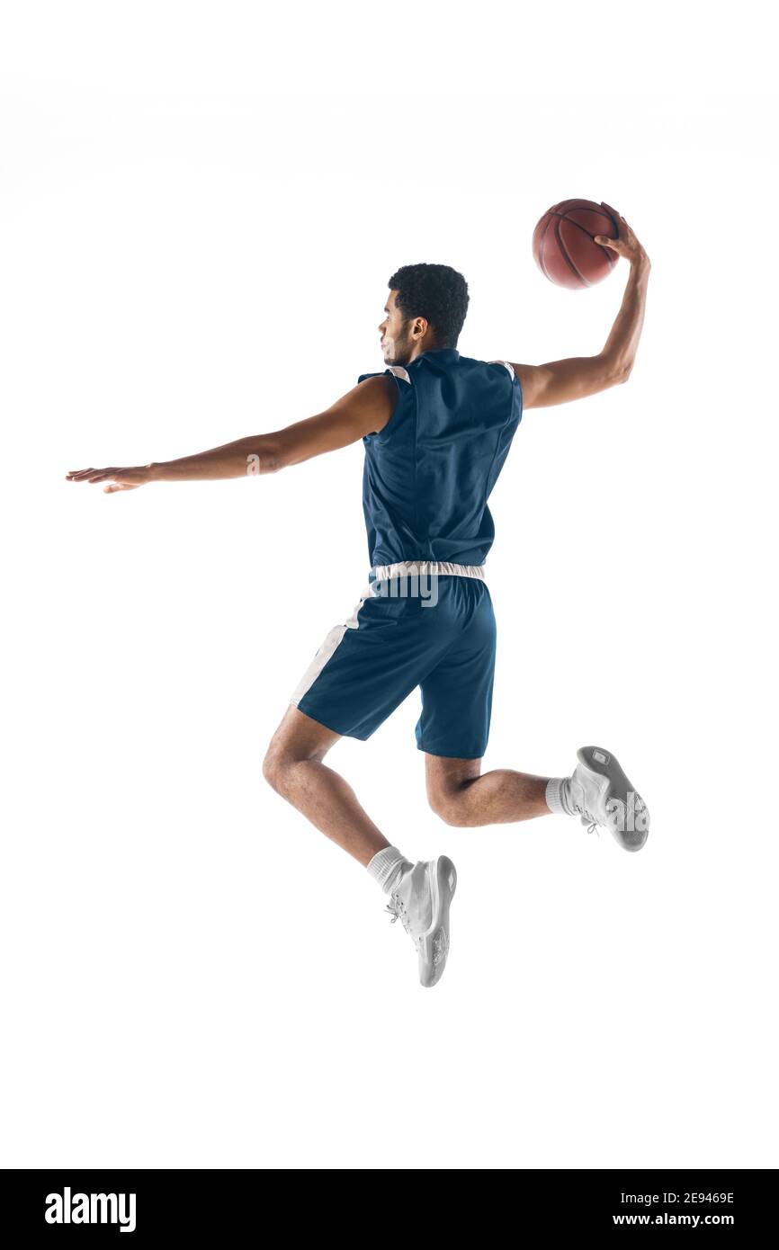 Vol élevé. Jeune joueur de basket-ball arabe musclé en action, le mouvement isolé sur fond blanc. Concept de sport, de mouvement, d'énergie et de mode de vie dynamique et sain. Formation, pratique. Banque D'Images