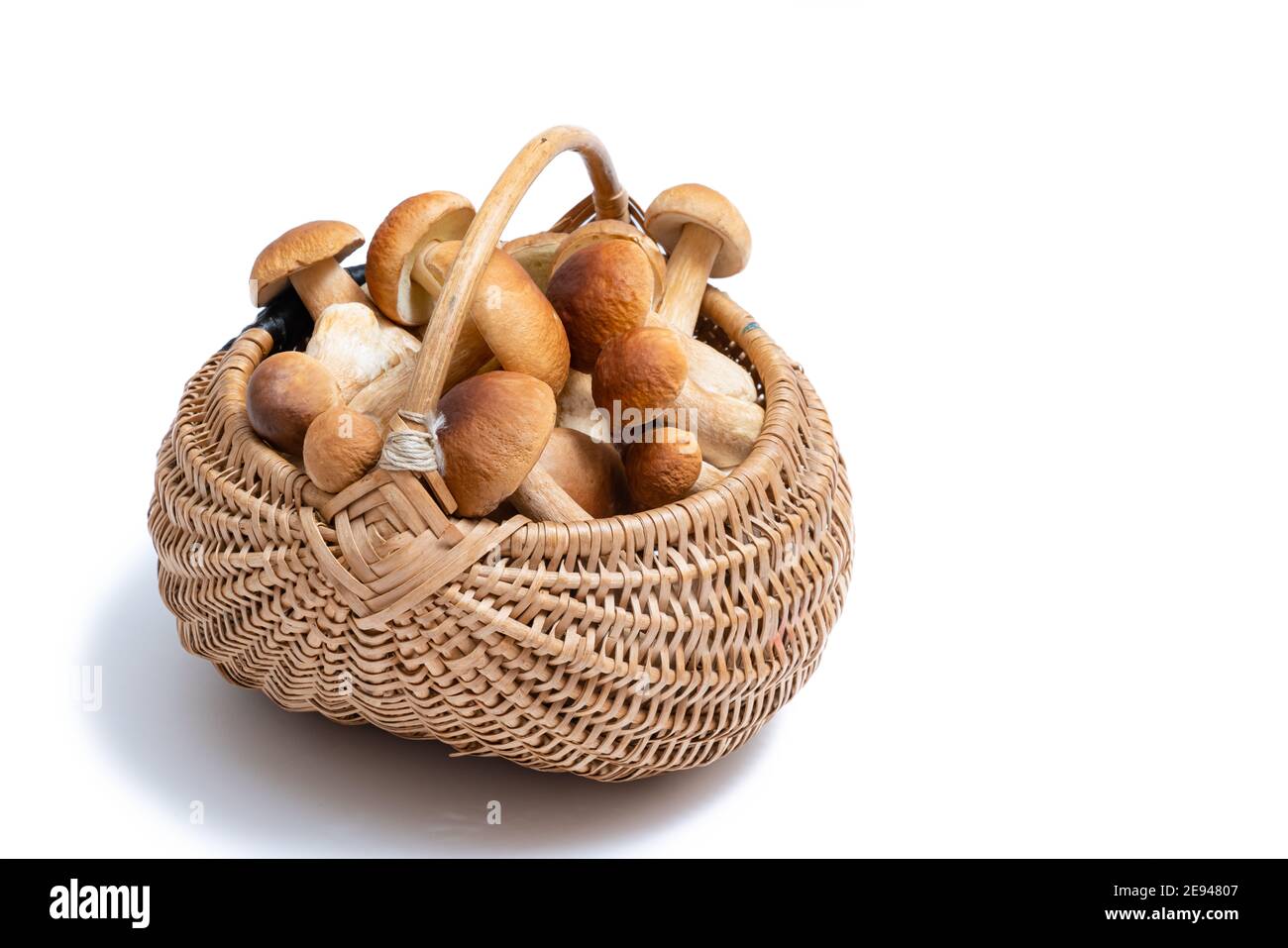 Panier en osier complet de Boletus edulis isolé sur fond blanc. Panier de champignons comestibles avec espace pour le texte. Personne Banque D'Images