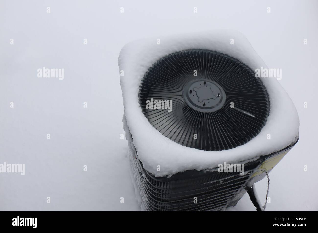 Unité de climatisation extérieure gelée après une tempête de neige et de verglas en hiver. Banque D'Images