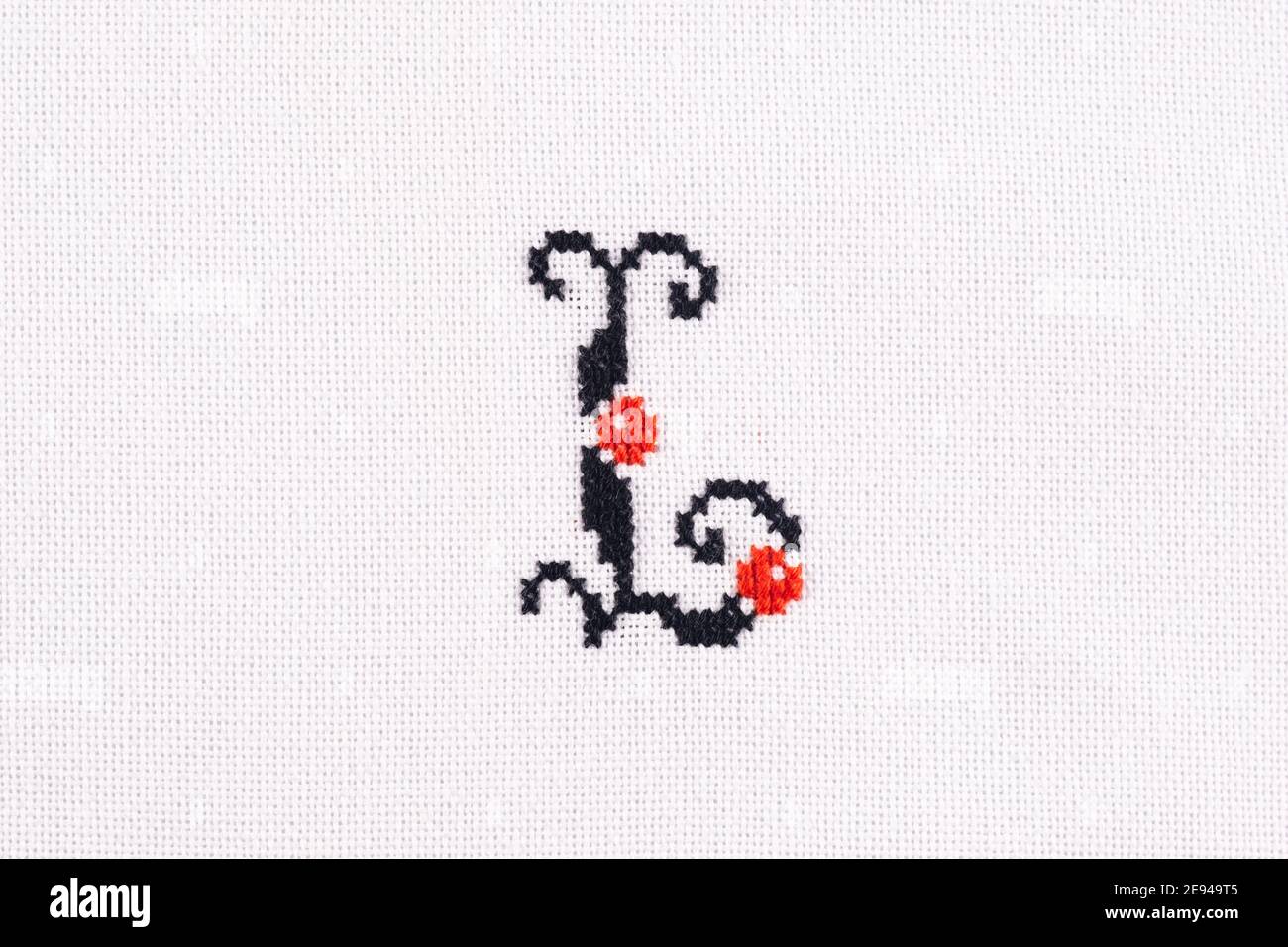 Lettre L de croix brodée - Stitch latin Alphabet on Gros plan en tissu de lin blanc fait main Banque D'Images
