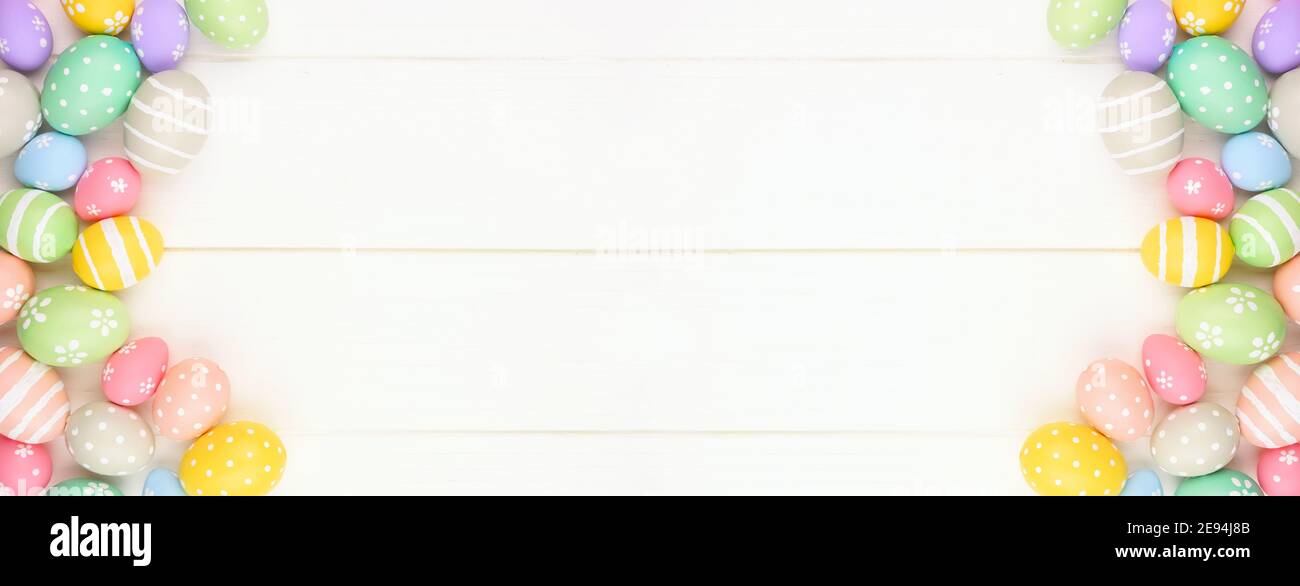 Bannière couleur pastel pour oeufs de Pâques avec bordure latérale double sur fond de bois blanc. Vue de dessus avec espace de copie. Banque D'Images