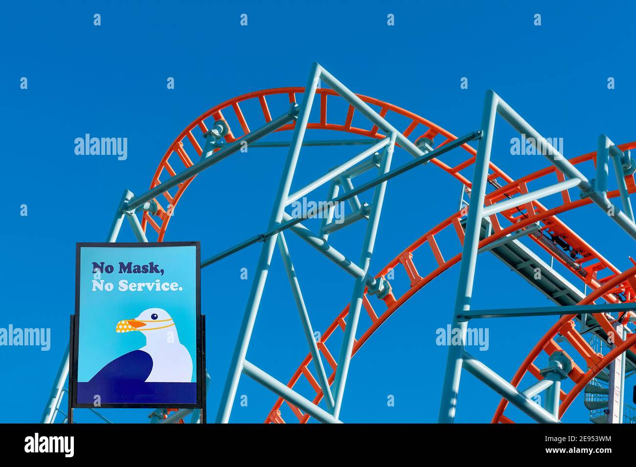 Santa Cruz, Californie, États-Unis - 18 janvier 2021 : montagnes russes à Santa Cruz, Californie, promenade sur la plage avec enseigne exigeant des masques. Les manèges restent clos Banque D'Images