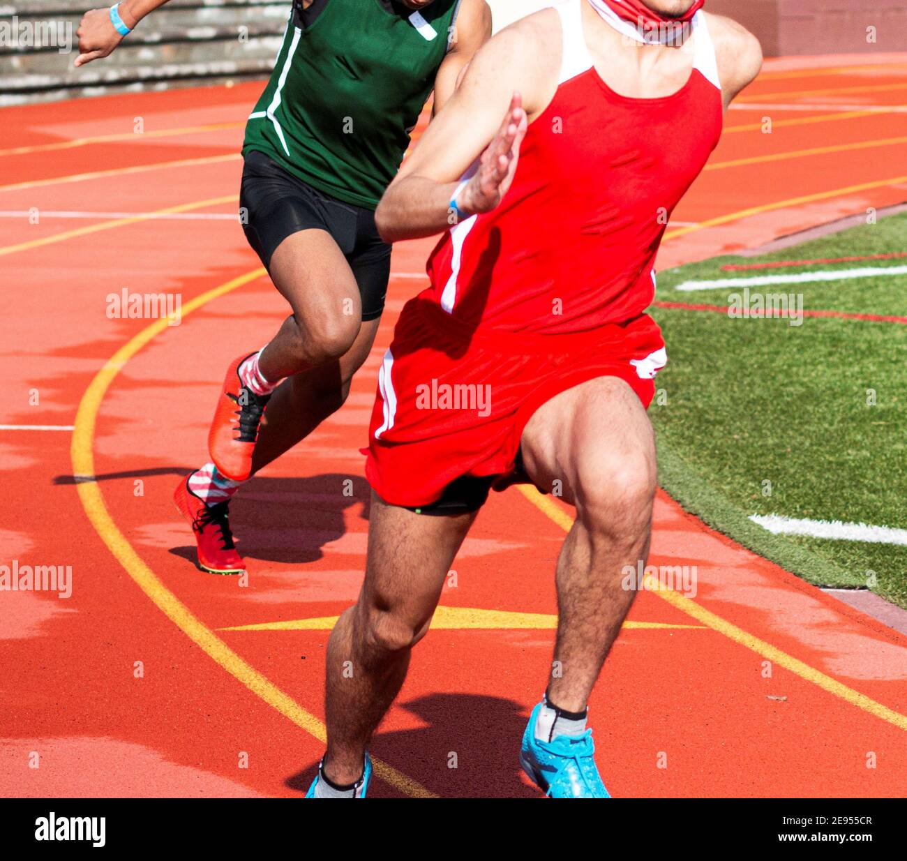 Deux garçons du secondaire qui se disputent une course de sprint sur une piste en plein air. Banque D'Images