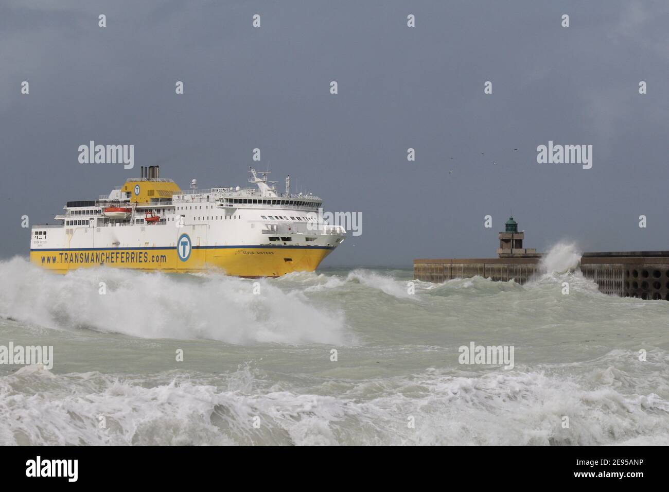 un grand ferry navigue à travers une mer sauvage avec de grands vagues pendant la tempête en automne jusqu'à la jetée à la côte française à dieppe Banque D'Images