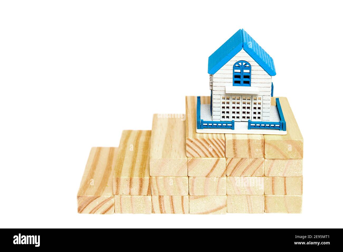 Doigts monter sur des blocs de bois à la maison miniature sur bois sur un fond blanc.le concept de croissance dans les affaires. Prêt de maison financière Banque D'Images