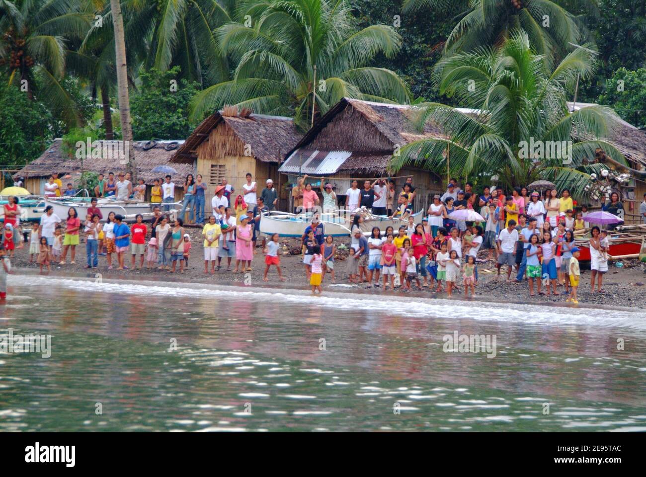 Les habitants du petit village de Himbangan accueillent le personnel de la Marine américaine depuis le rivage, vu à partir d'un bateau gonflable rigide de Hull de 11 mètres déployé à partir du quai d'atterrissage amphibie USS Harpers Ferry le 20 février 2006. Des équipes ont été déployées pour effectuer une enquête sur l'atterrissage à la plage de la région. Les navires DE la Marine AMÉRICAINE fournissent une aide humanitaire aux victimes de la municipalité de Saint Bernard, où la ville de Guinsahudon située dans la partie sud de l'île a été complètement dévastée lors d'un glissement de terrain du 17 février. Photo USN via ABACAPRESS.COM Banque D'Images