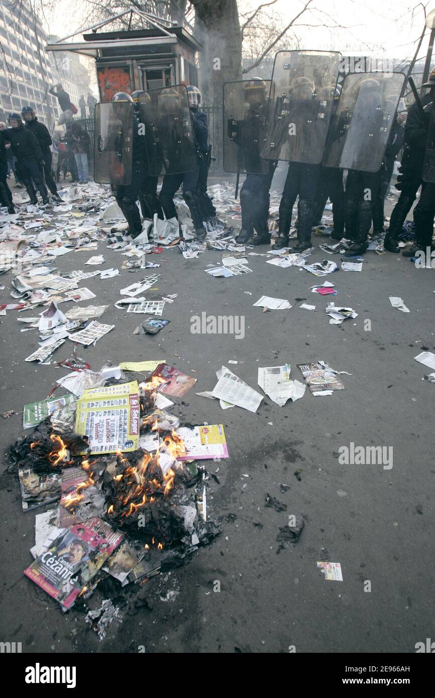 Les policiers anti-émeutes font face aux manifestants lorsqu'un kiosque à journaux brûle, à Paris, en France, lors d'une manifestation dans le cadre des manifestations étudiantes prévues le 16 mars 2006 à travers la France pour forcer le gouvernement à abandonner le premier contrat d'emploi (CPE), un contrat à durée indéterminée pour les moins de 26 ans qui peut être résilié dans les deux premières années sans explication. Photo de Mousse-Taamallah/ABACAPRESS.COM Banque D'Images