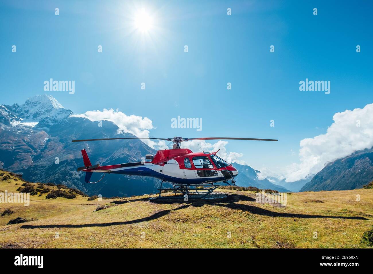 Un hélicoptère civil a atterri dans les montagnes de l'Himalaya en haute altitude. Thamserku 6608m de montagne en arrière-plan. Namche Bazar, Népal. Transport d'air de sécurité Banque D'Images