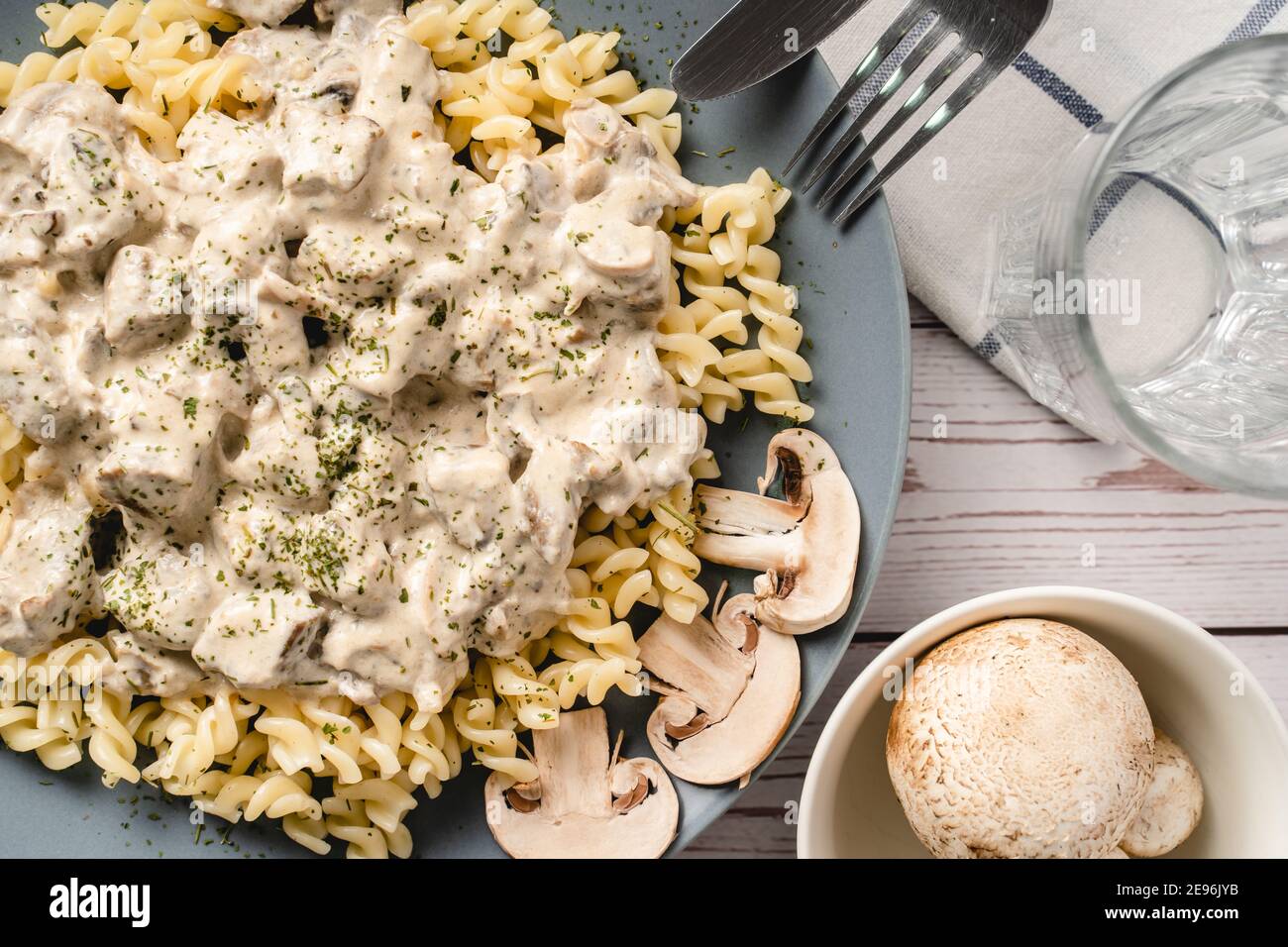 Tagliatelle pâtes italiennes avec champignons champignon blanc de la forêt sauce crémeuse et poulet ou viande de bœuf - plats faits maison dans l'assiette sur la vue du dessus de la table Banque D'Images