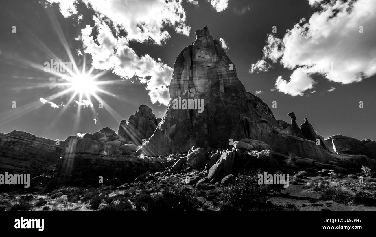 Noir et blanc photo du soleil au-dessus des formations de grès le long de la promenade panoramique Arches dans le parc national d'Arches près de Moab, Utah, États-Unis Banque D'Images