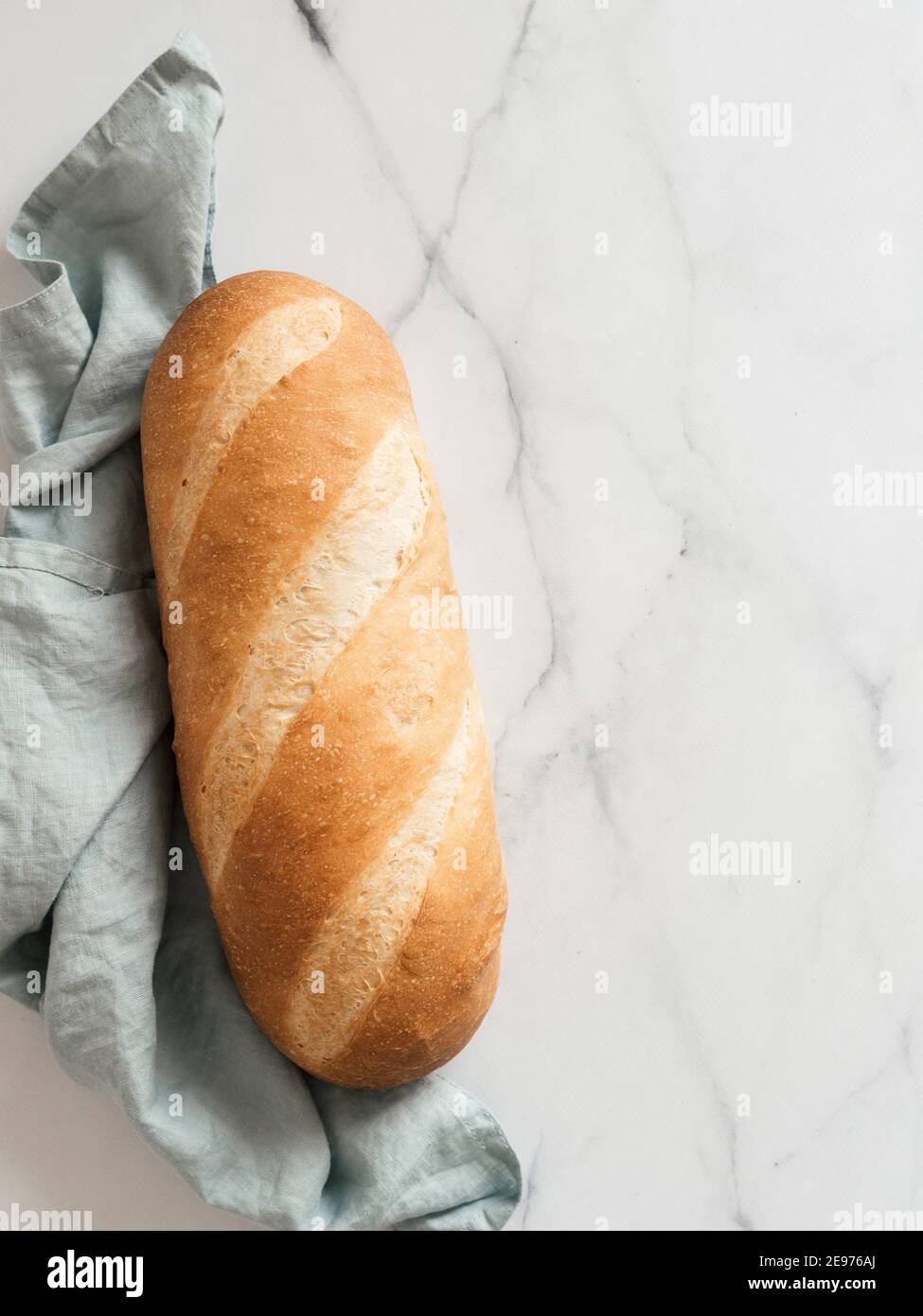 Pain de pain de blomer blanc britannique ou de pain de bâton européen sur fond de marbre blanc. Vue de dessus ou plan d'étapage. Copier l'espace pour le texte ou la conception. Verticale. Banque D'Images