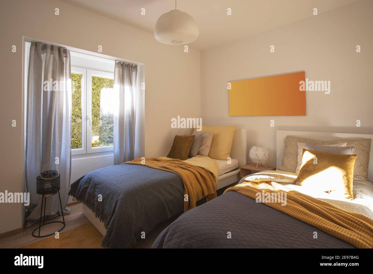 Chambre moderne avec deux lits simples, draps propres et grand oreiller au-dessus. Mur blanc. Personne à l'intérieur. Banque D'Images