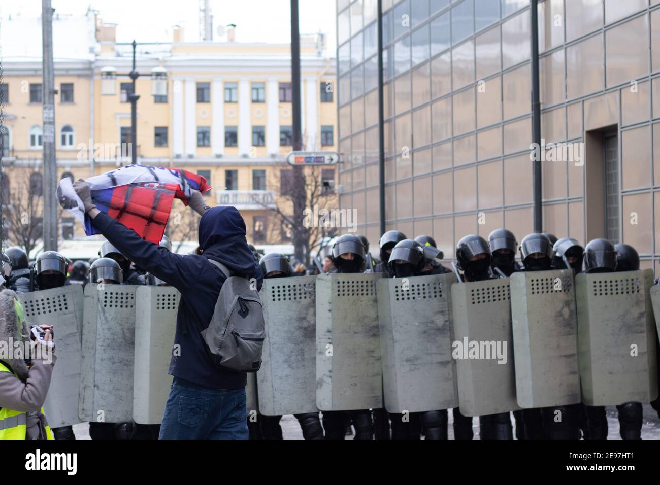 Saint-Pétersbourg, Russie - 31 janvier 2021 : activiste avec drapeau russe à côté de la police anti-émeute avec boucliers , protestation en Russie, Editorial Banque D'Images