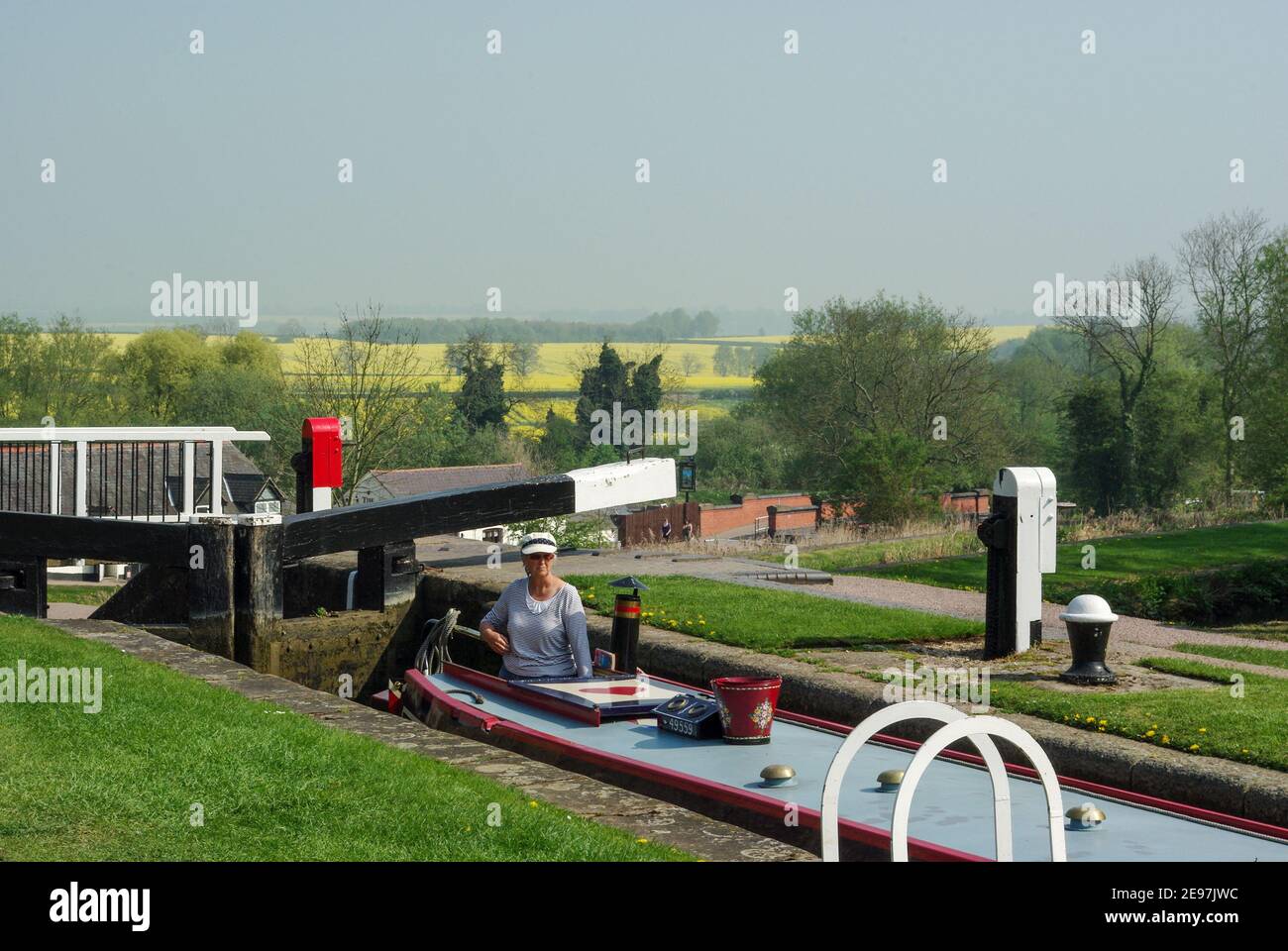 Foxton écluses sur le canal de Grand Union , Foxton, Leicestershire, Royaume-Uni; femme en bateau à narrowboat naviguant sur le vol historique des écluses. Banque D'Images