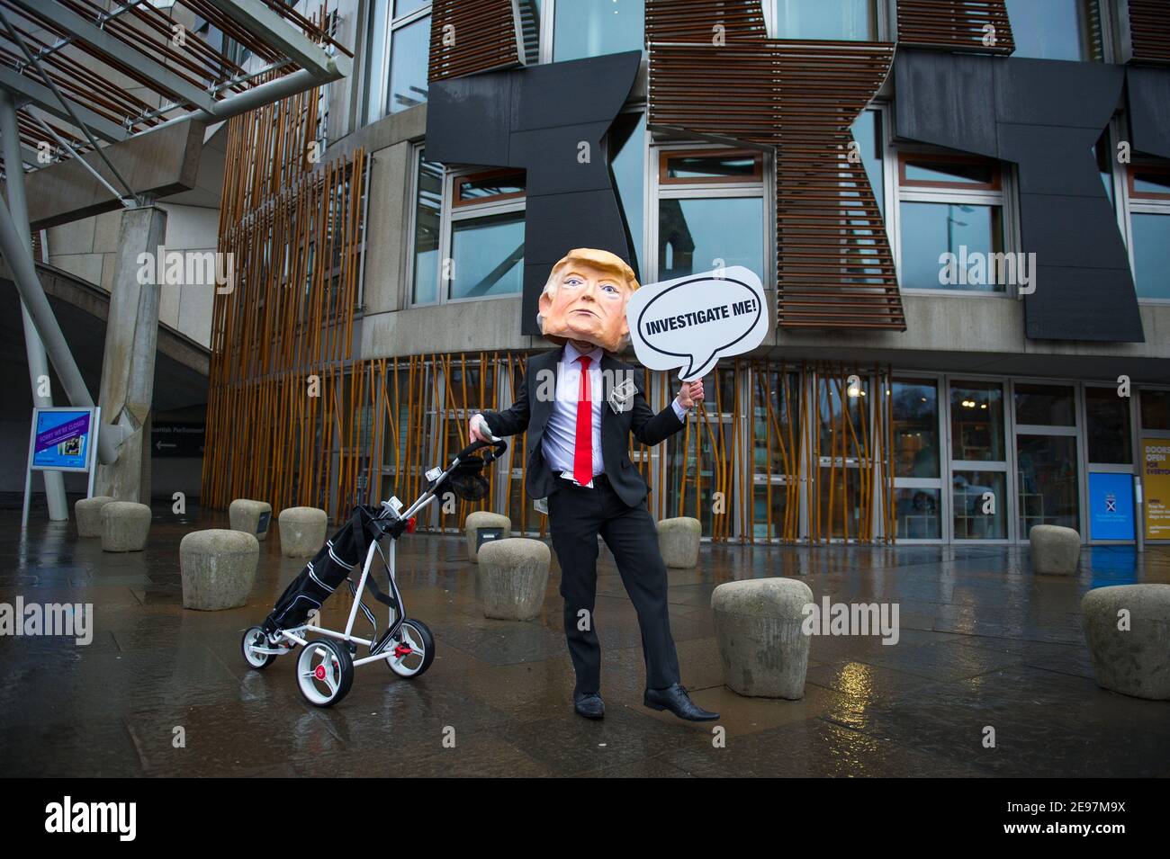 Édimbourg, Écosse, Royaume-Uni. 3 février 2021. Photo : avant un débat et un vote au Parlement écossais pour décider si le gouvernement écossais doit enquêter sur le financement par Donald Trump des terrains de golf écossais, les militants dépeigneront un faux Trump portant une tête géante, une cravate rouge et portant un panneau indiquant « Investigate Me! » En dehors du Parlement écossais. Il va également traîner son sac de golf débordant avec des billets de dollar. Crédit : Colin Fisher/Alay Live News Banque D'Images