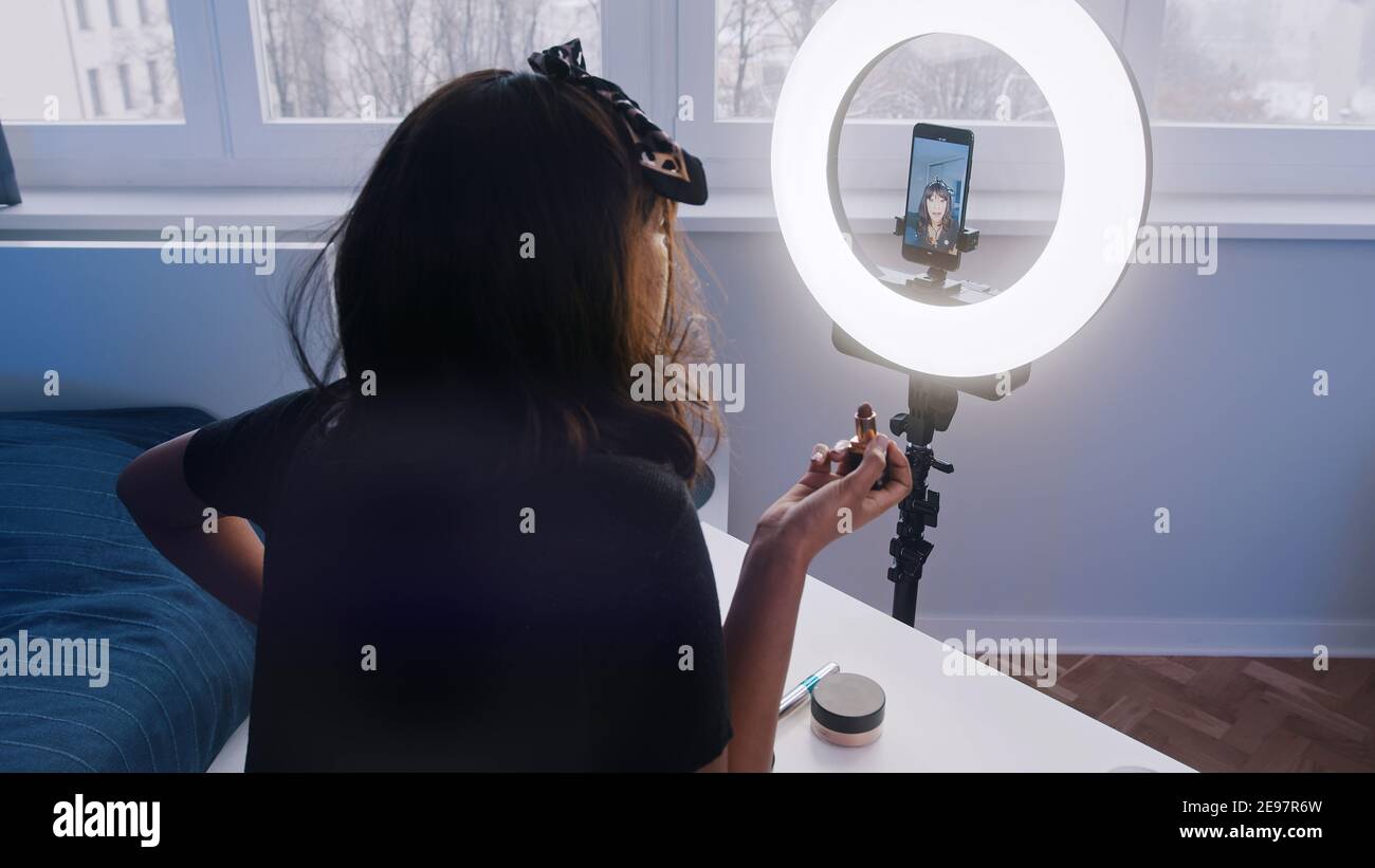 Jeune femme avec enregistrement de cheveux noirs maquillage tutoriel. Application du maquillage devant l'appareil photo. Photo de haute qualité Banque D'Images
