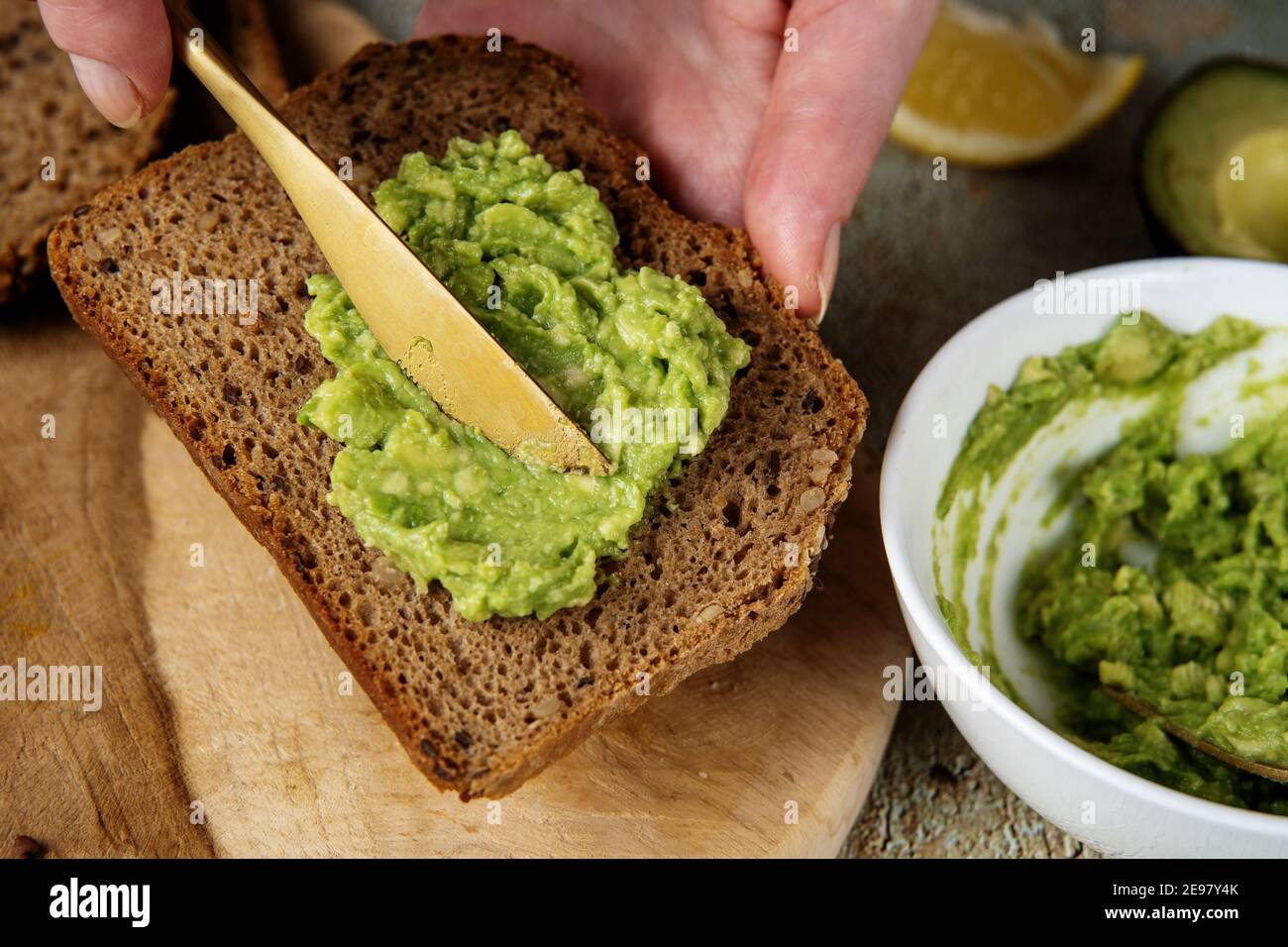 Avocado écrasé. Étendre l'avocat émincé sur une tranche de pain saine Banque D'Images