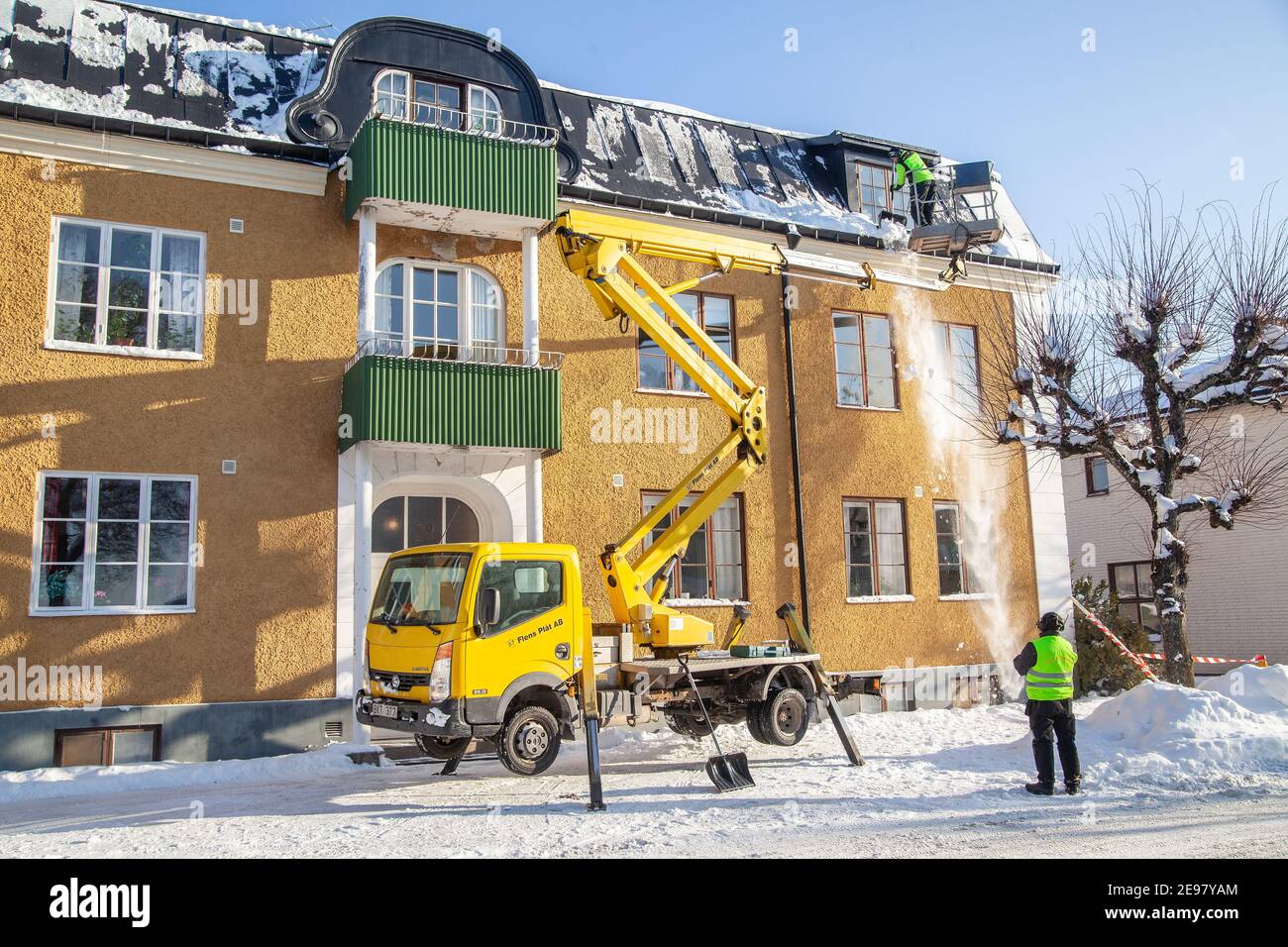 Travailleur sur le monte-ciel déneigement de toit à Malmkoping. Photo: Bo Arrhed Banque D'Images