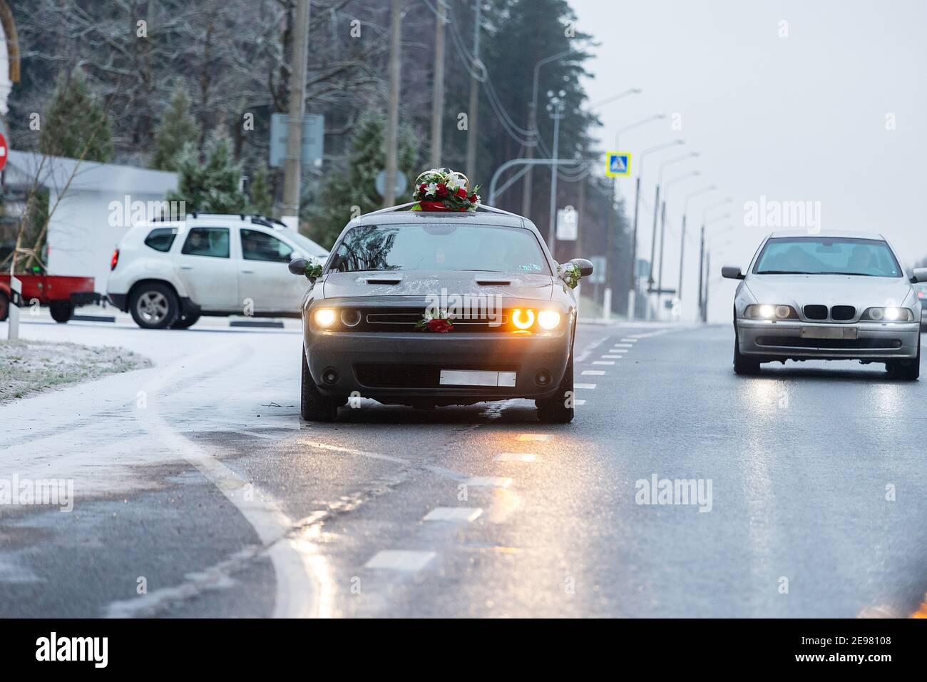 la voiture roule sur une autoroute enneigée en hiver, les mauvaises conditions météorologiques et l'asphalte glissant exigent une conduite prudente et une vitesse réduite pour des raisons de sécurité Banque D'Images