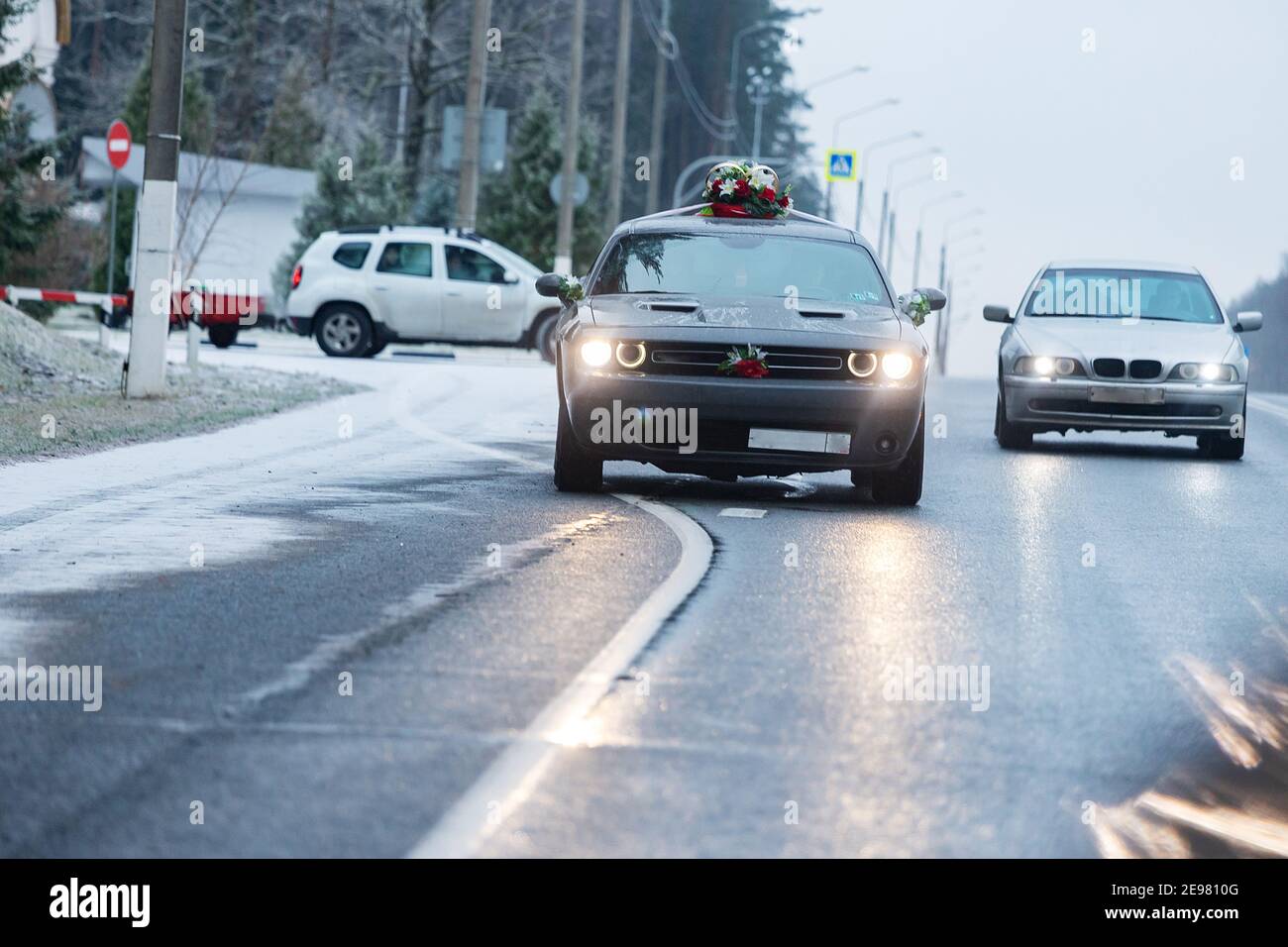 la voiture roule sur une autoroute enneigée en hiver, les mauvaises conditions météorologiques et l'asphalte glissant exigent une conduite prudente et une vitesse réduite pour des raisons de sécurité Banque D'Images