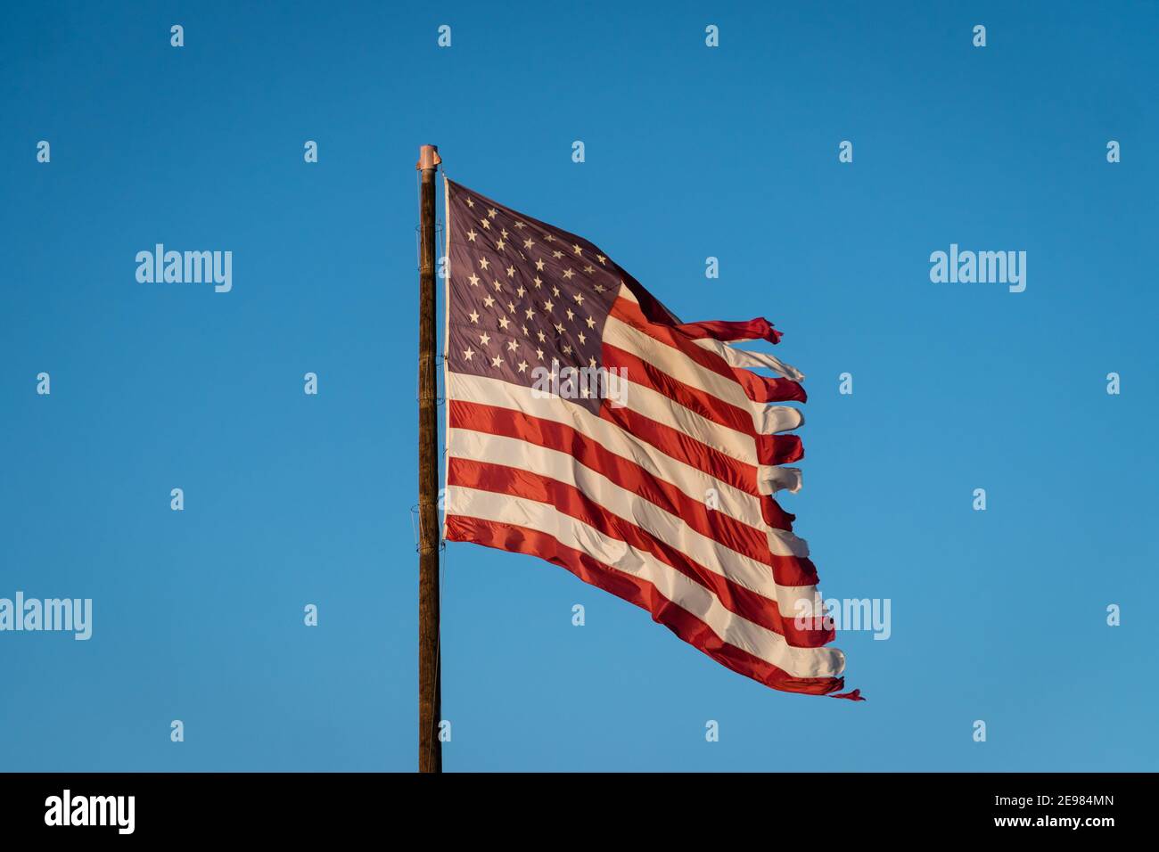 Drapeau américain flatté contre un ciel bleu brillant Banque D'Images