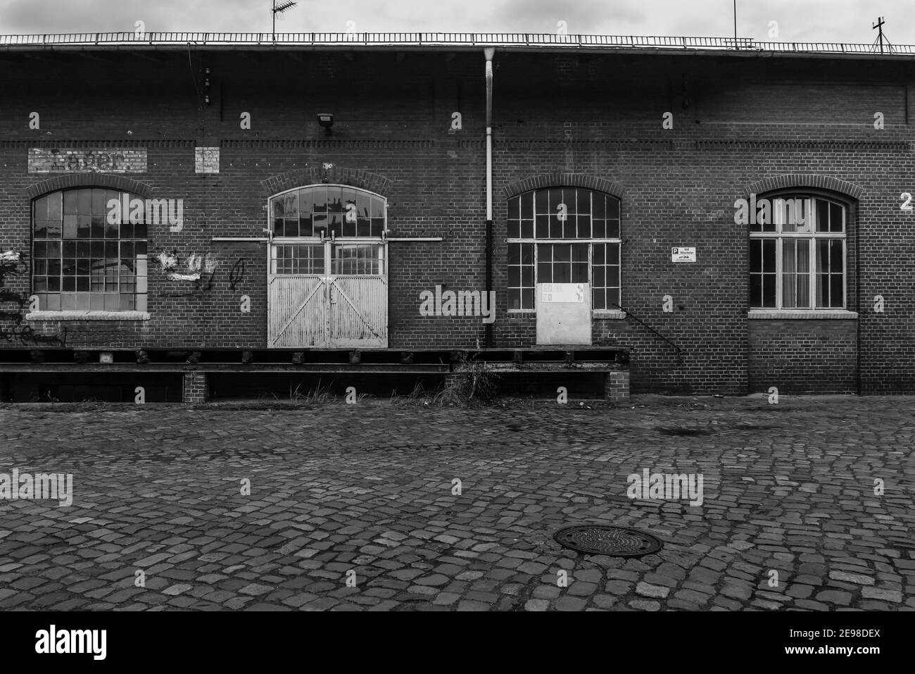 La rampe de chargement d'un ancien entrepôt, la rampe de chargement et une porte coulissante d'un ancien entrepôt, photo en noir et blanc Banque D'Images