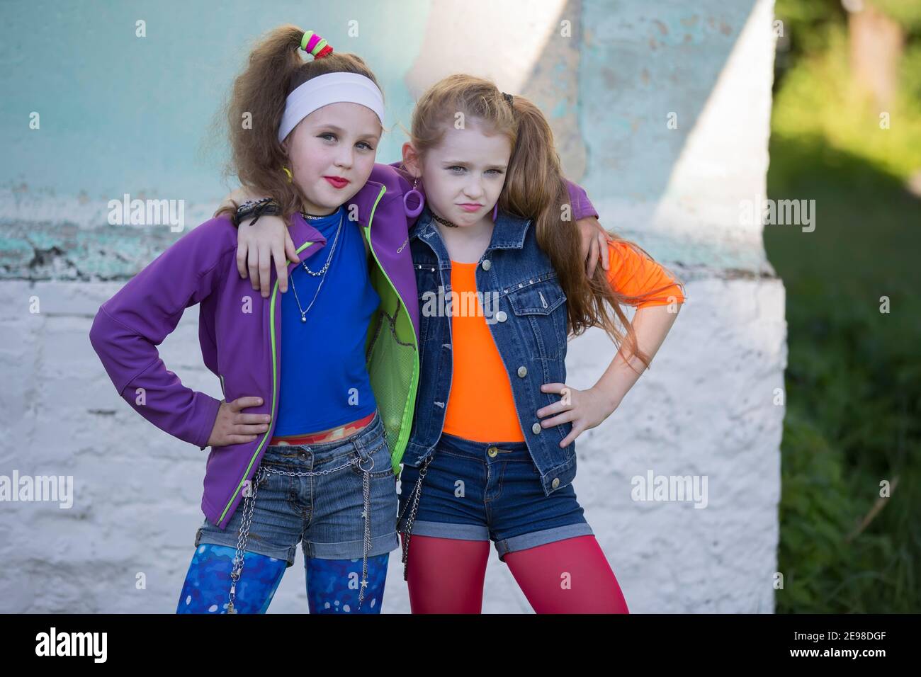 Deux sont drôles petites filles avec le maquillage brillant habillé dans le style des années 90. Banque D'Images