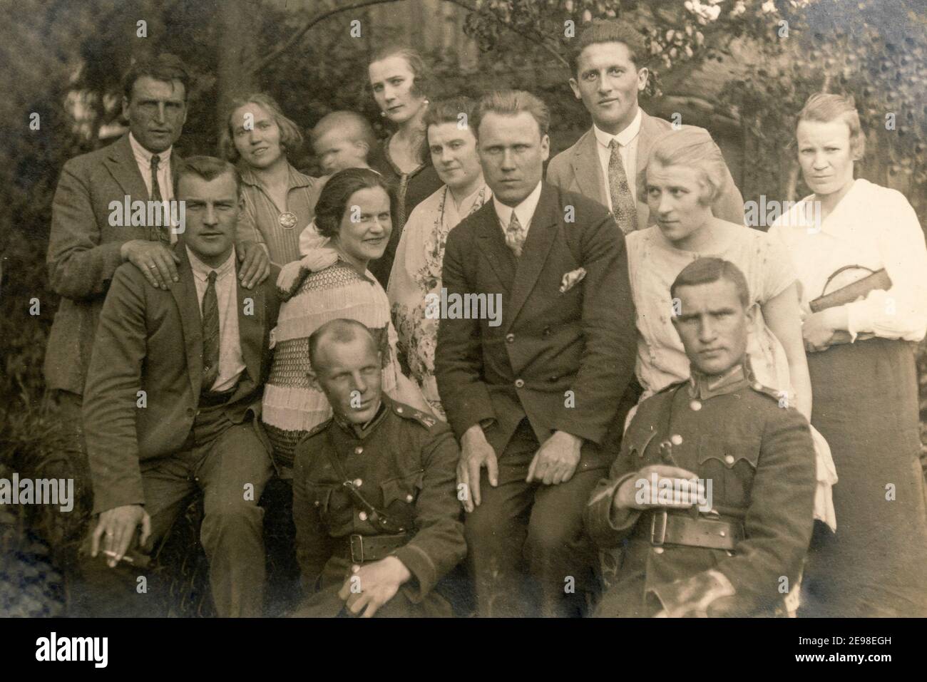 Lettonie - VERS les années 1920 : photo de groupe des invités de la fête. Quelques hommes en uniforme. Ancienne photo d'archive historique Banque D'Images