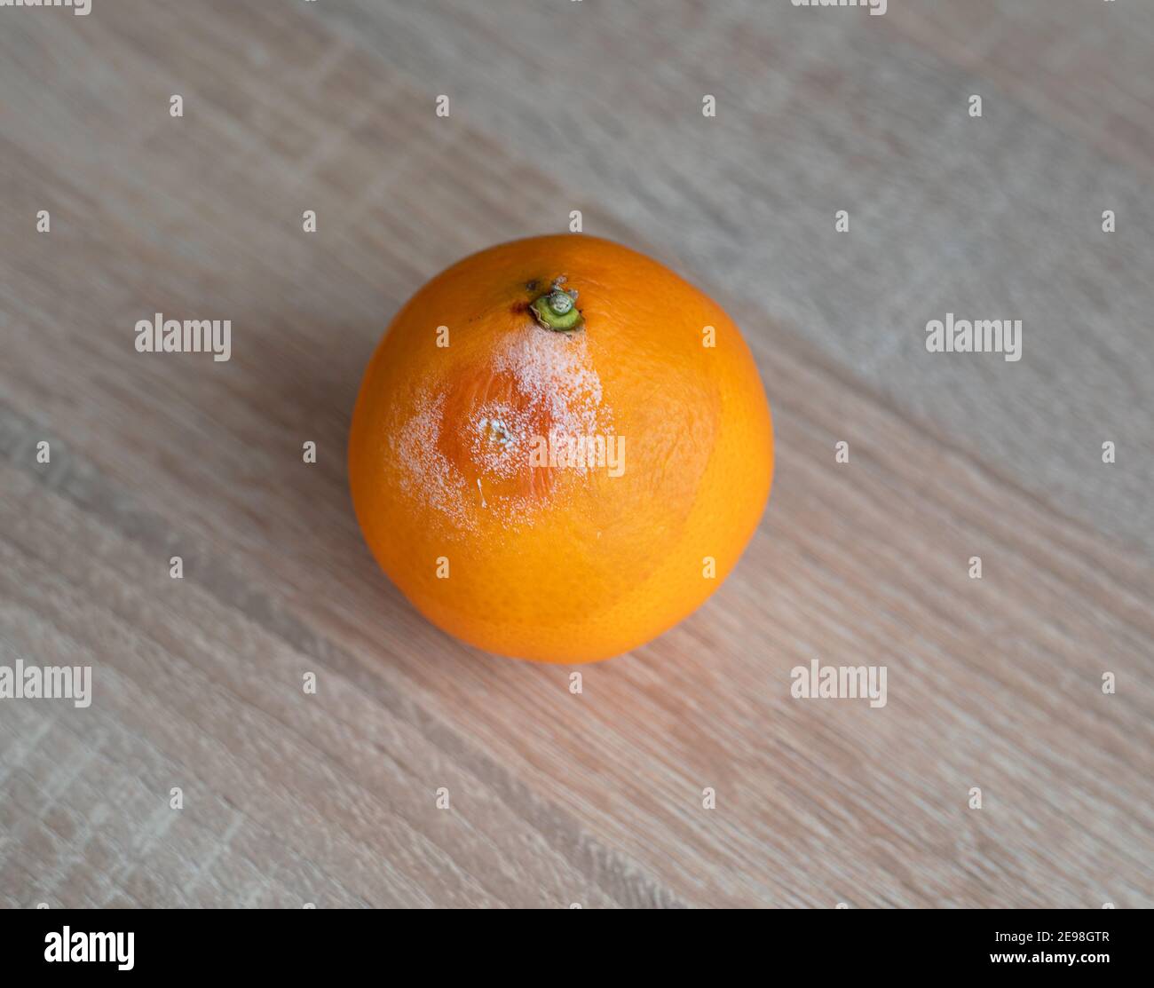 Fruits orange moisi pourri sur table en bois Banque D'Images